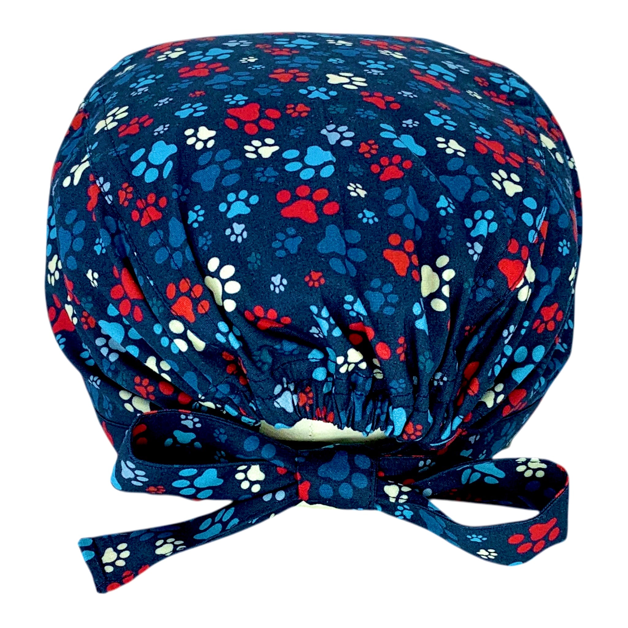 L'orma di una zampa di cane o gatto declinata in varie dimensioni e colori su base blu delinea un pattern semplice, vivace ed elegante al tempo stesso.