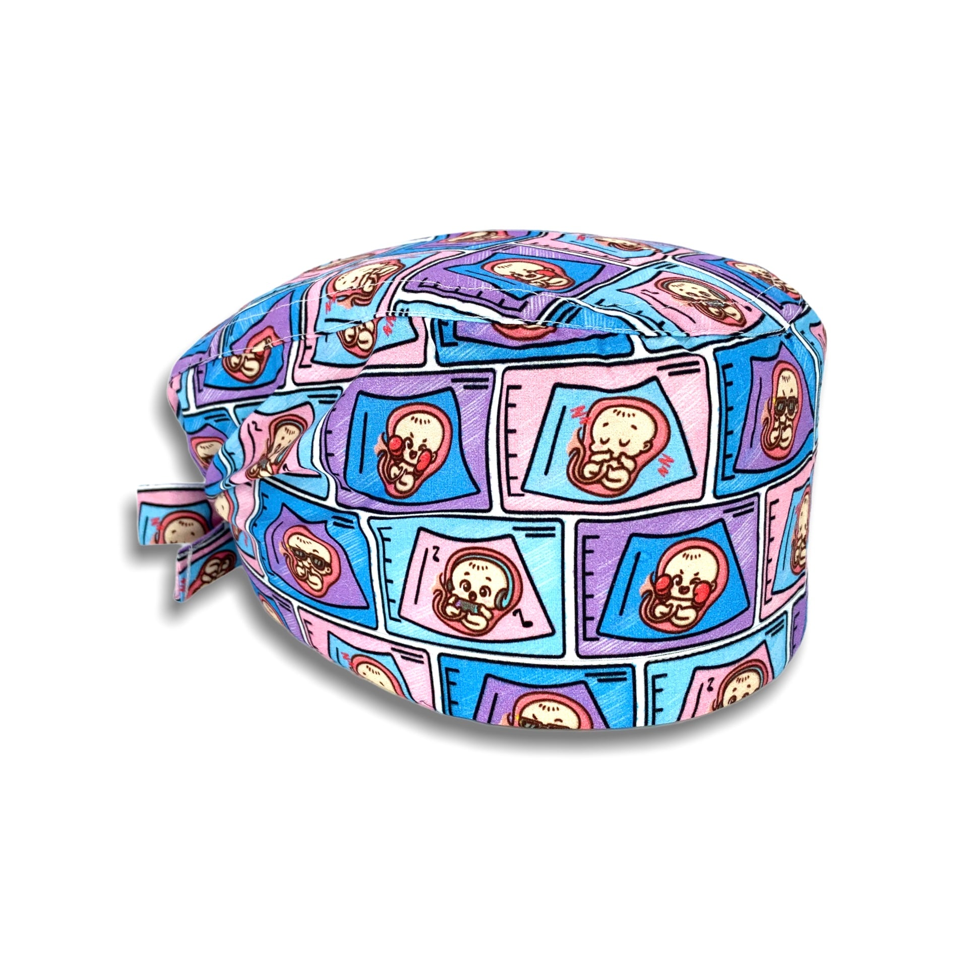 Una cuffietta con immagini cartoon di un bebè visto nell'ecografo, sfondo bianco e disegni lilla, rosa, azzurro