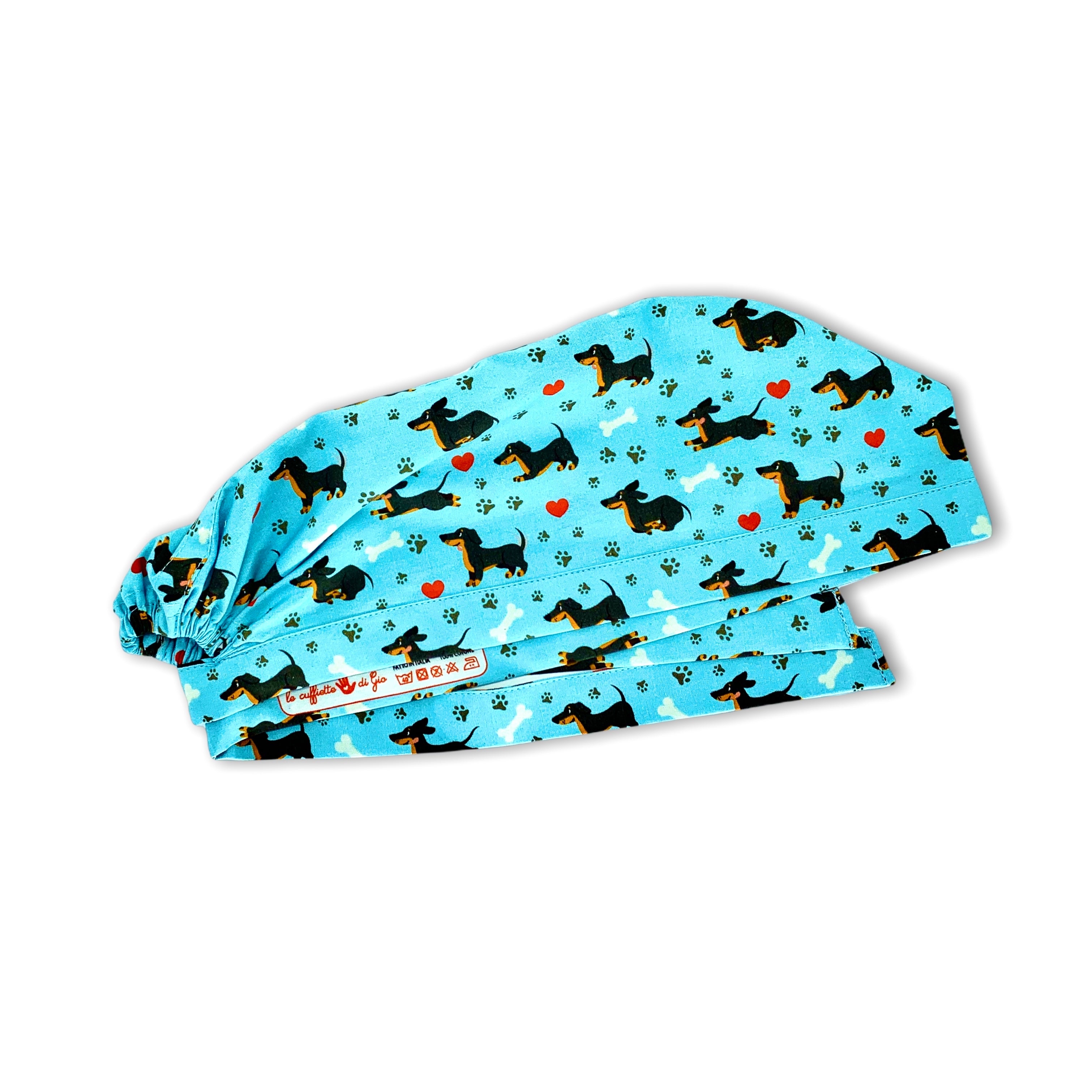 Un simpatico bassotto corre felice fra impronte di zampette, ossi da sgranocchiare e cuoricini in una combinazione di colori vincente!