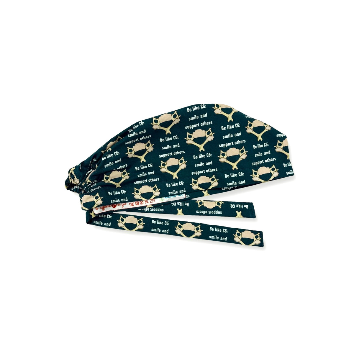 In questa cuffietta chirurgica un meme si trasforma in un simpatico pattern, ideale per neurochirurghi e per chi vuole promuovere simpaticamente lo spirito di squadra, una vertebra C6 stilizzata sembra un mostriciattolo sorridente e si abbina alla frase in inglese "sii come C6: sorridi e supporta gli altri" su sfondo blu petrolio