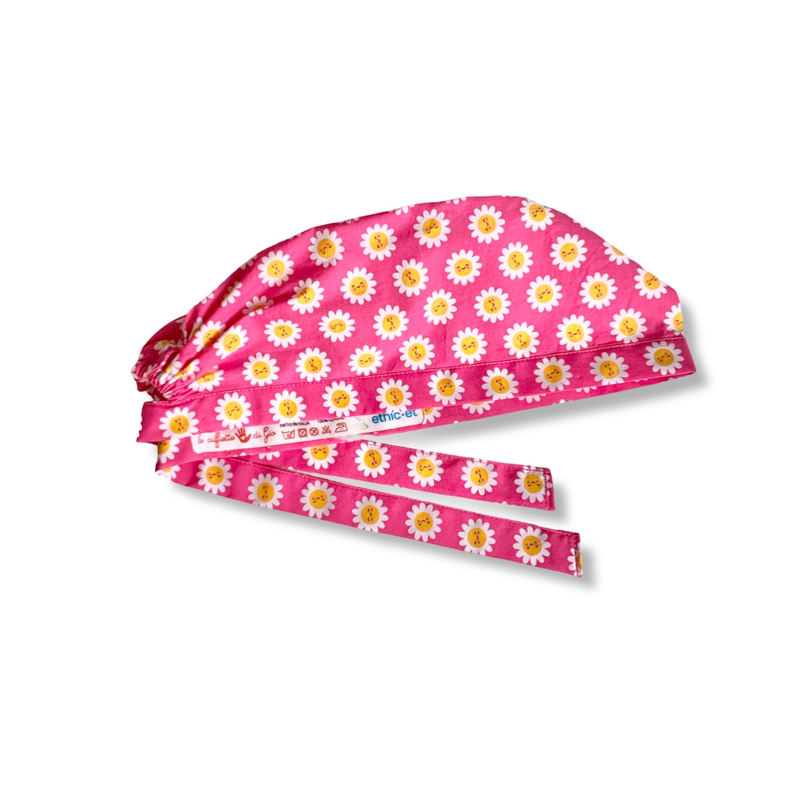 La bellezza di questa cuffia chirurgica sta nella sua semplicità e nell'esplosività dei colori: piccole margherite con faccine sorridenti su sfondo fucsia.
