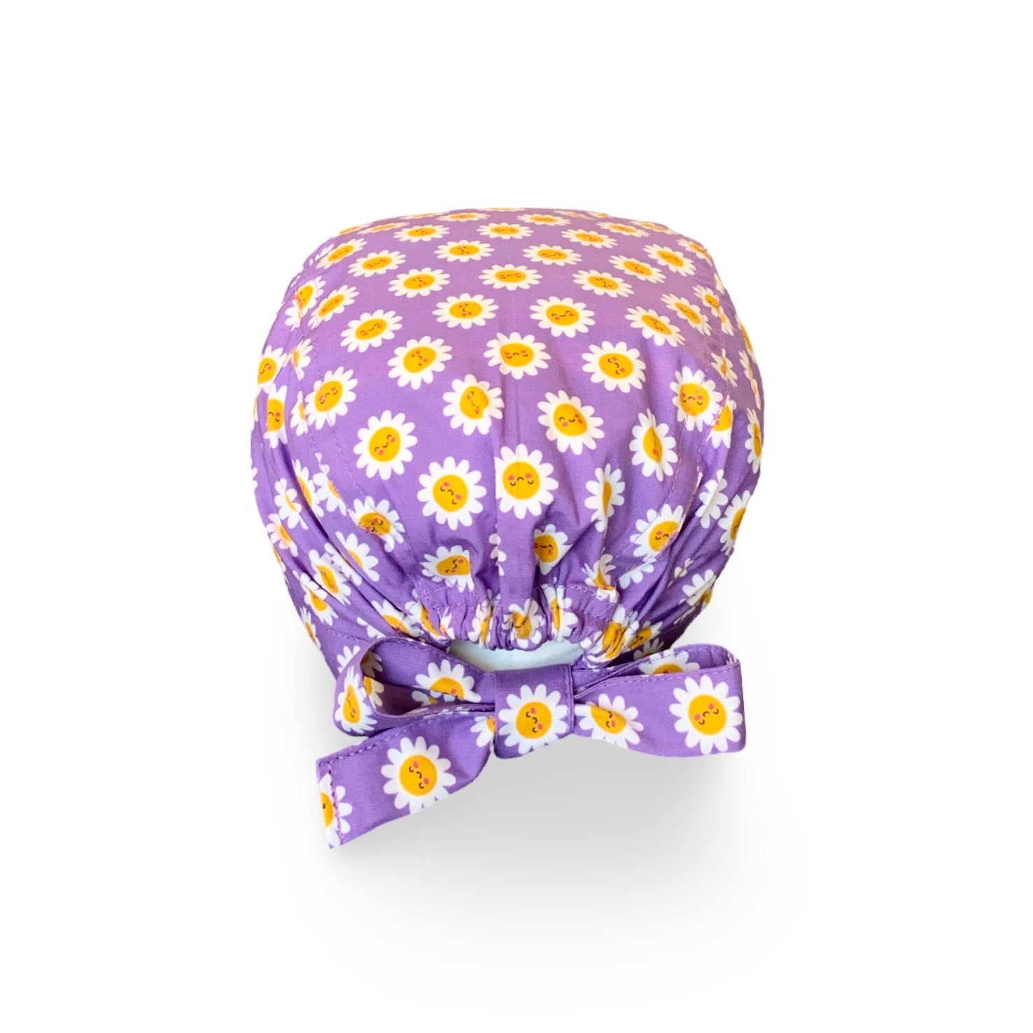 La bellezza di questa cuffietta chirurgica sta nella sua semplicità e nell'esplosività dei colori: piccole margherite con faccine sorridenti su sfondo lilla o turchese.
