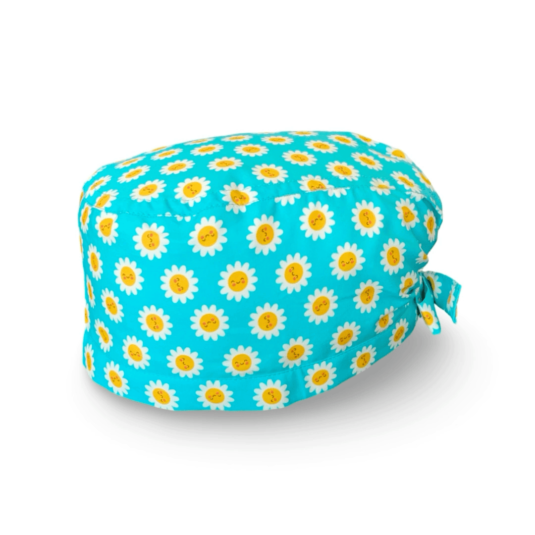 La bellezza di questa cuffietta chirurgica sta nella sua semplicità e nell'esplosività dei colori: piccole margherite con faccine sorridenti su sfondo fucsia, lilla o turchese.