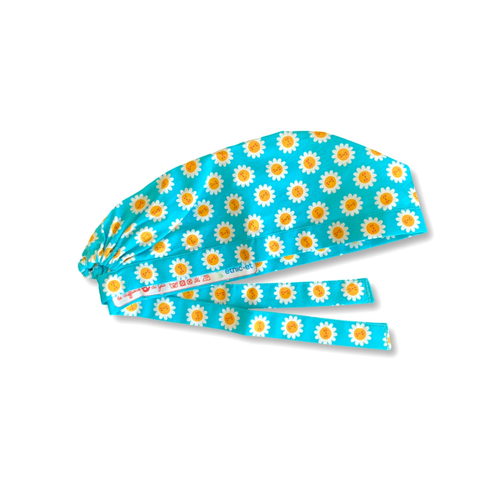 La bellezza di questa cuffietta chirurgica sta nella sua semplicità e nell'esplosività dei colori: piccole margherite con faccine sorridenti su sfondo lilla o turchese.