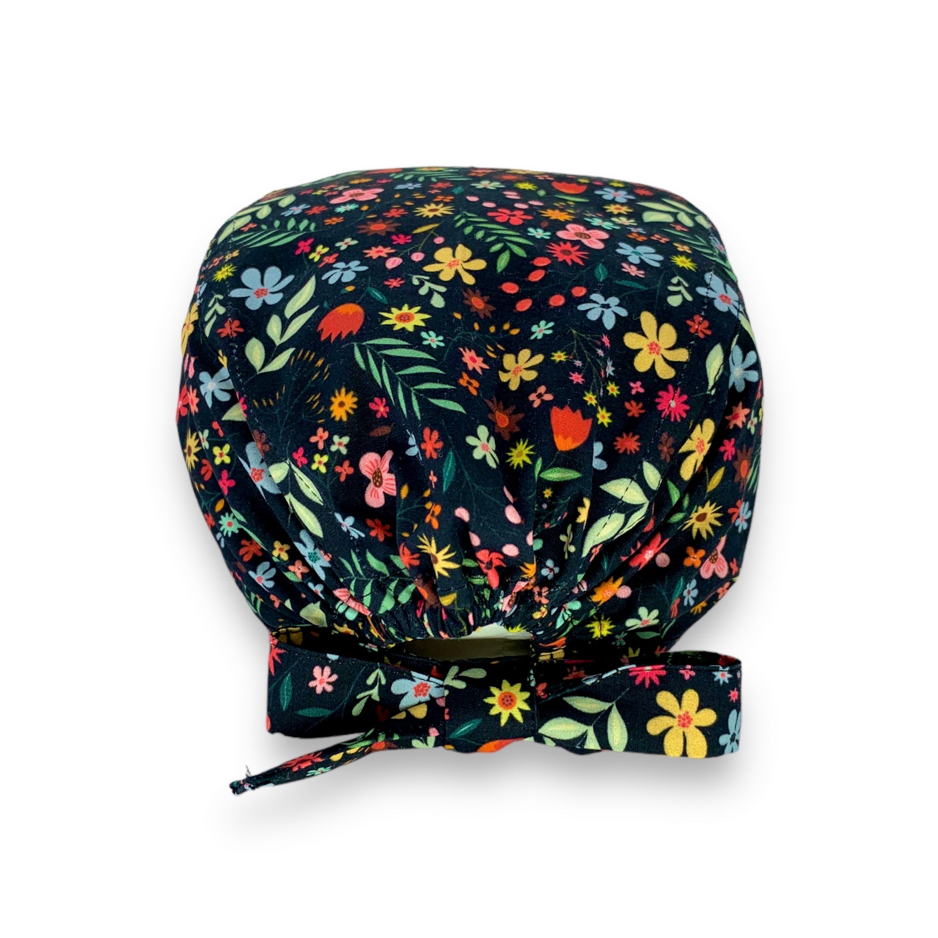 Cuffietta chirurgica con fiori nelle calde tonalità di rossi e gialli che si mescolano a foglie delicate, fiorellini rosa e azzurri per ricordare colori e profumi delle campagne. Sfondo panna