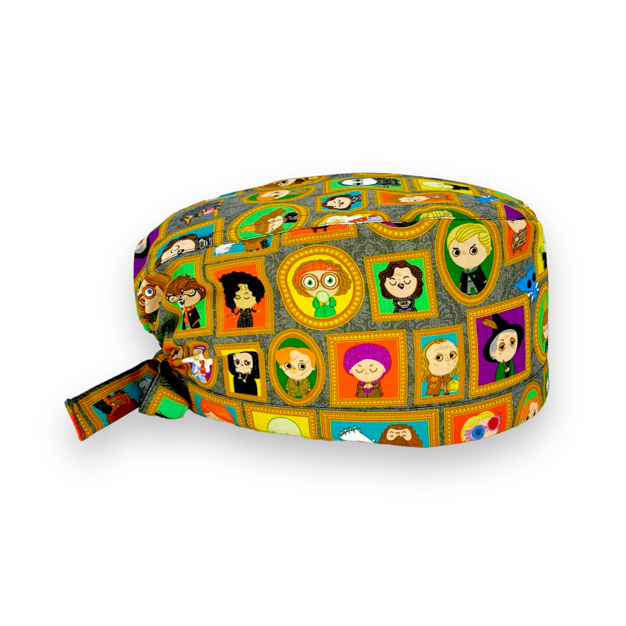 Cuffietta chirurgica con vivaci ritratti dei personaggi della saga sulla scuola di magia più misteriosa della letteratura, tutti incorniciati da cornici dorate e appesi a uno sfondo con carta da parati floreale grigia tono su tono