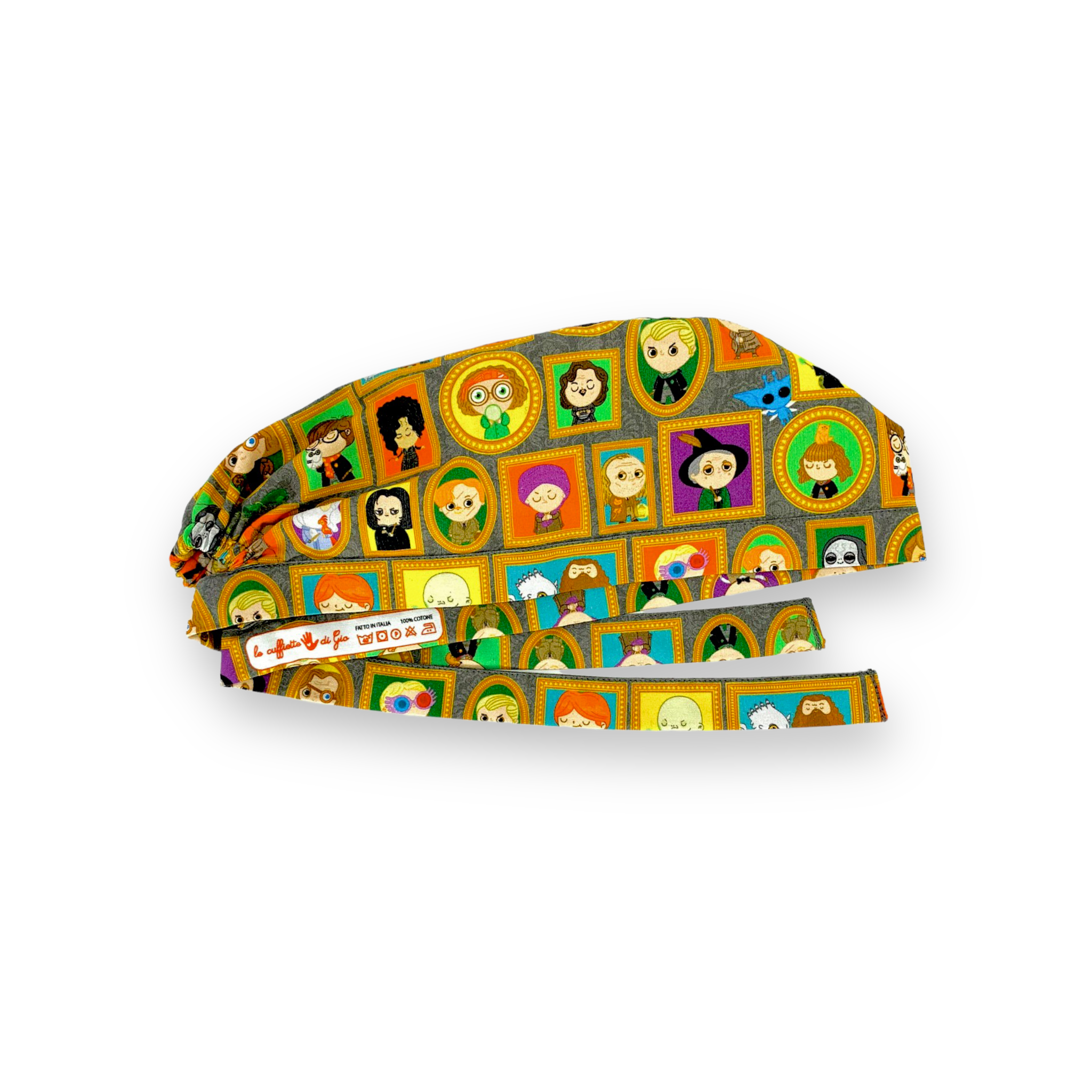 Cuffietta chirurgica con vivaci ritratti dei personaggi della saga sulla scuola di magia più misteriosa della letteratura, tutti incorniciati da cornici dorate e appesi a uno sfondo con carta da parati floreale grigia tono su tono