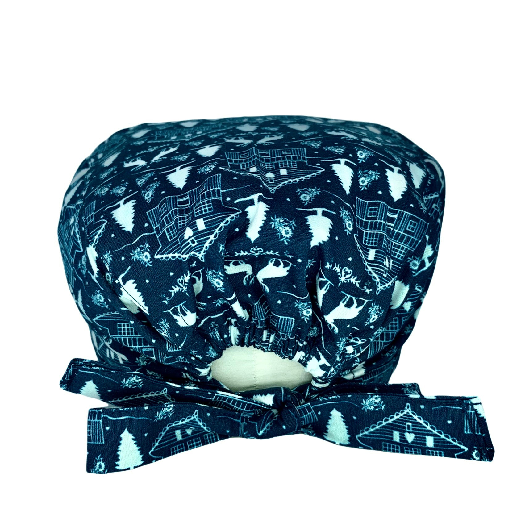 Cuffietta chirurgica blu avio con una baita, i pini coperti di neve e i cervi che passeggiano nei boschi.