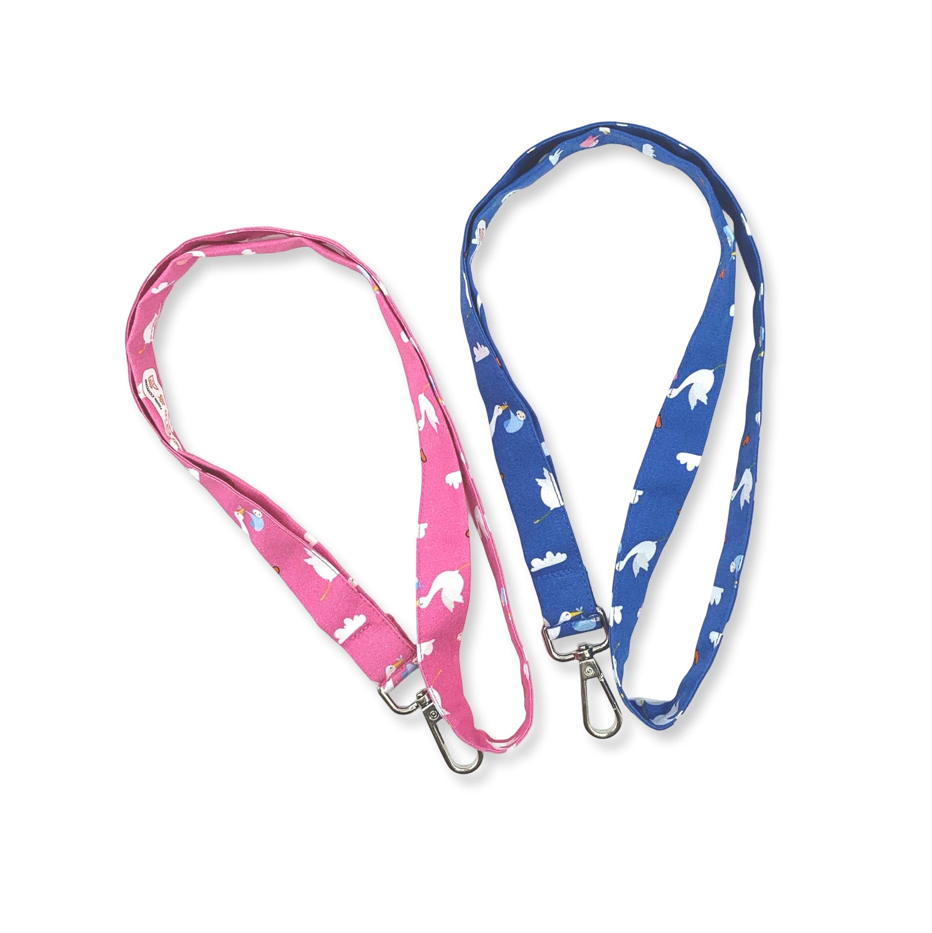 Una fascetta da collo portabadge con tante cicogne che portano un dono prezioso; sfondo blu o fucsia, è lunga 45 cm e corredata di moschettone in metallo separabile per il lavaggio grazie al bottone automatico
