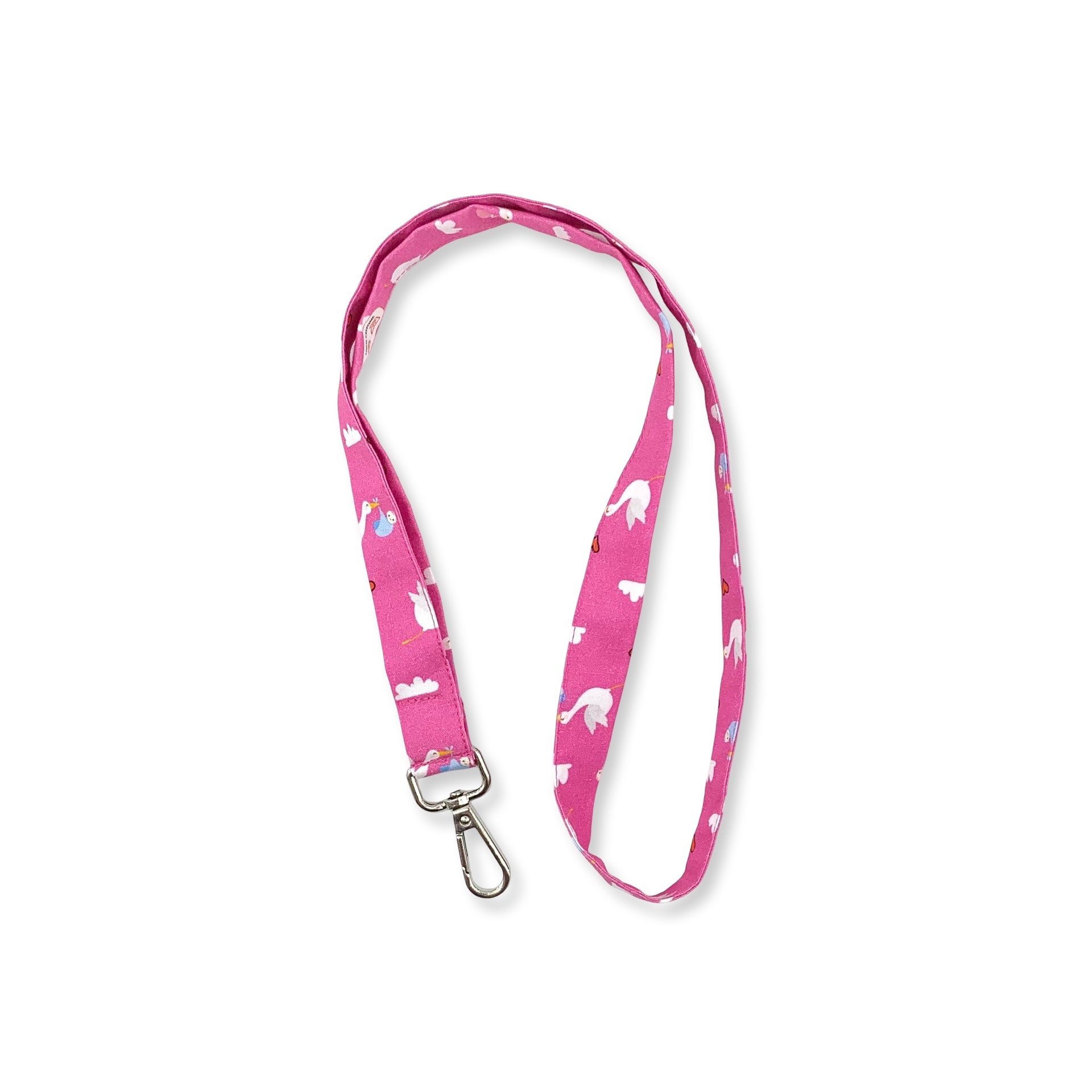Una fascetta da collo portabadge con tante cicogne che portano un dono prezioso; sfondo fucsia, è lunga 45 cm e corredata di moschettone in metallo separabile per il lavaggio grazie al bottone automatico