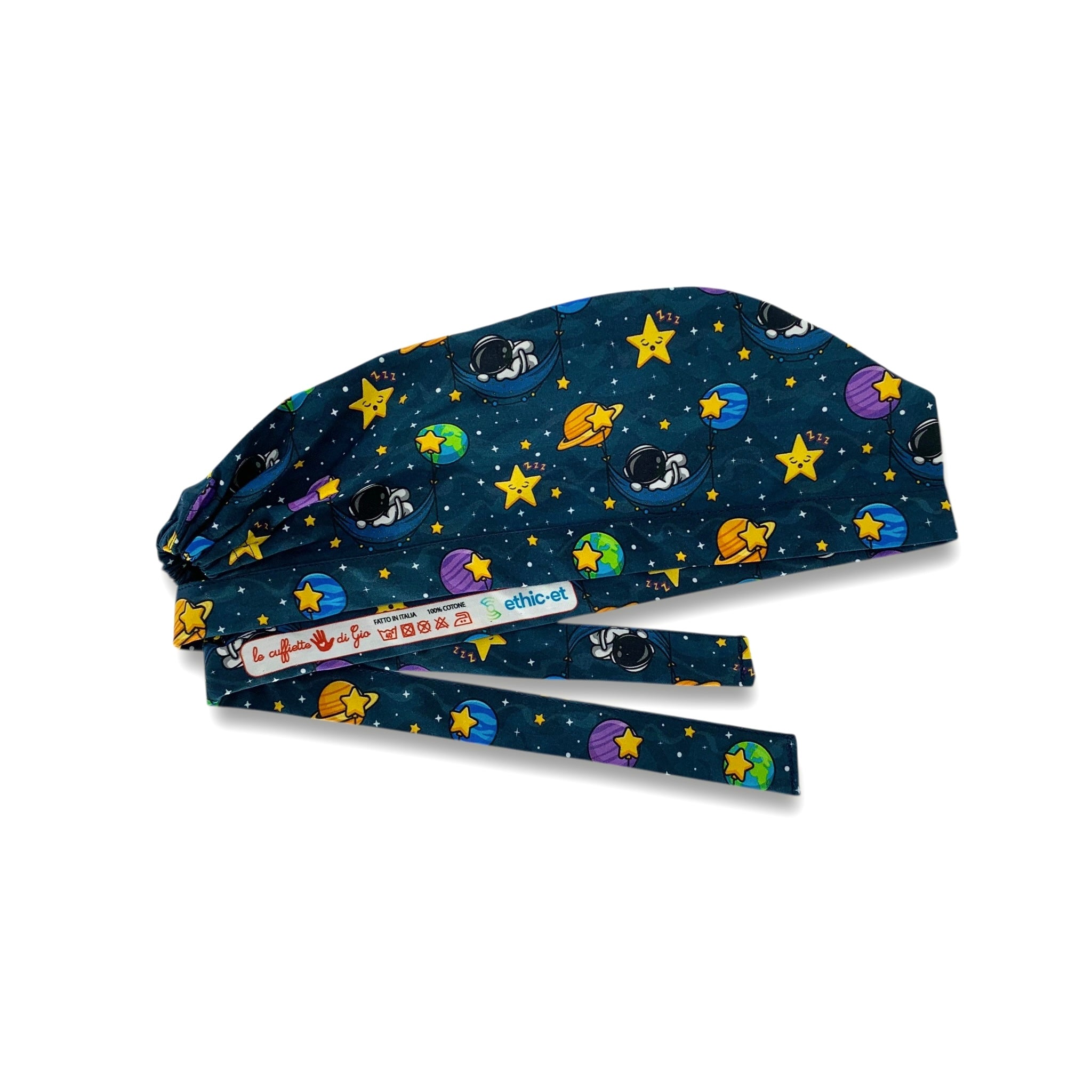 Una cuffietta chirurgica poetica ed evocativa, che parla di spazio, stelle e sogni. Un cielo notturno blu scuro accoglie degli astronauti che dormono su amache appese a pianeti colorati. Il tutto contornato da stelline gialle pisolanti