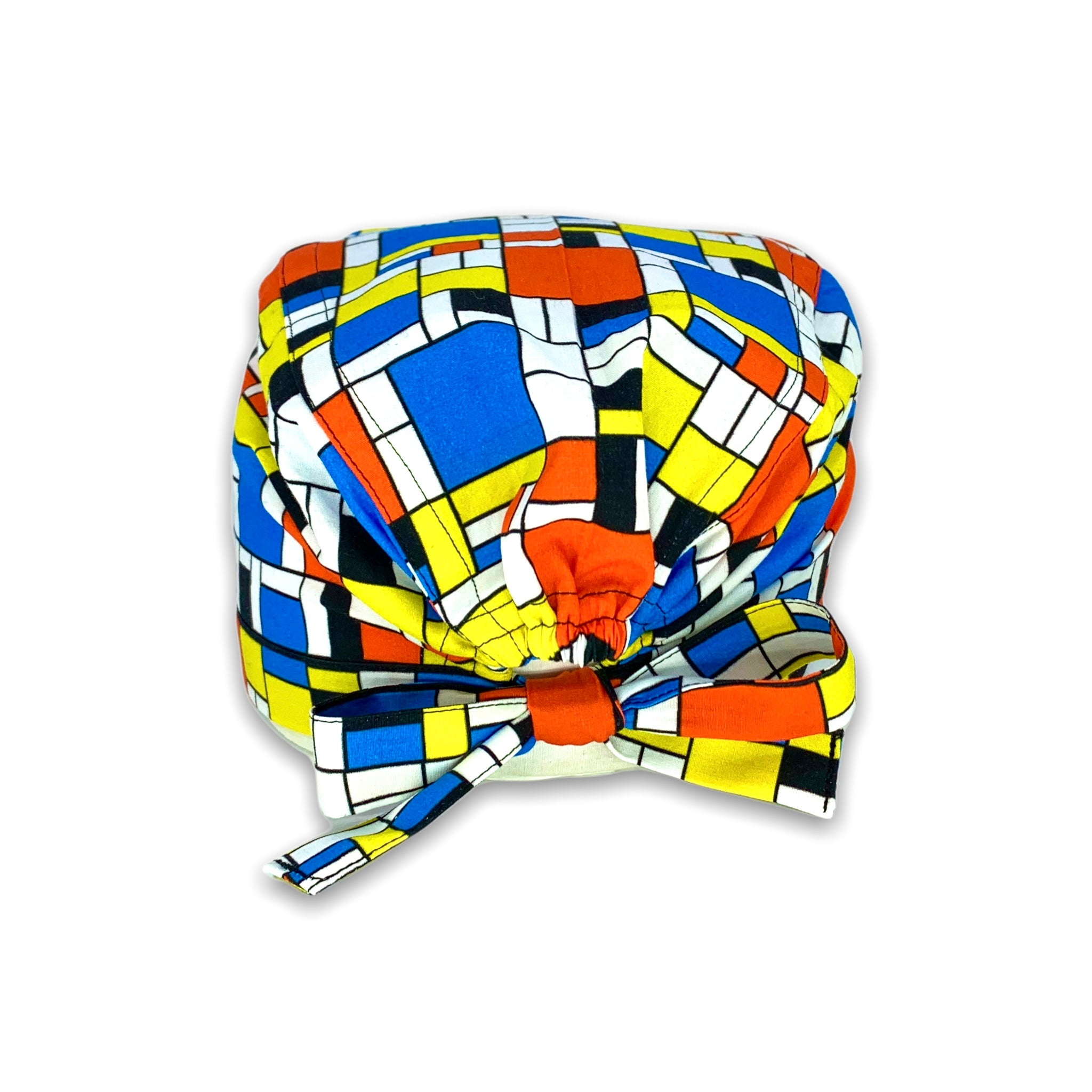 Cuffietta chirurgica che riproduce i disegni geometrici dei quadi di Mondrian, con i colori caratteristici blu, rosso, giallo e nero su  sfondo bianco