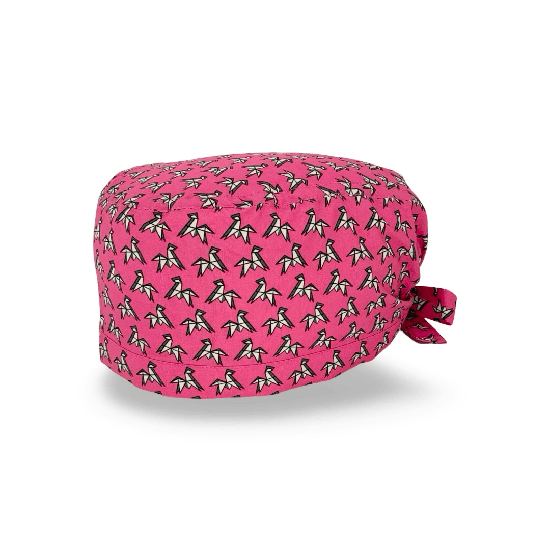 Una cuffietta chirurgica con un pattern elegantissimo formato da un disegno origami stilizzato di un cavallo, ispirato a una famosa cravatta, su fondo blu avio o fucsia.