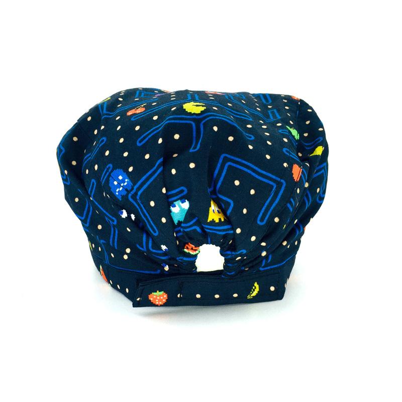 Cuffietta chirurgica che riproduce il videogioco in cui una pallina gialla mangia delle pedine ed è inseguita da piccoli fantasmi colorati che possono eliminarla. Nel percorso nero ci sono dei separatori blu ed altri elementi del gioco