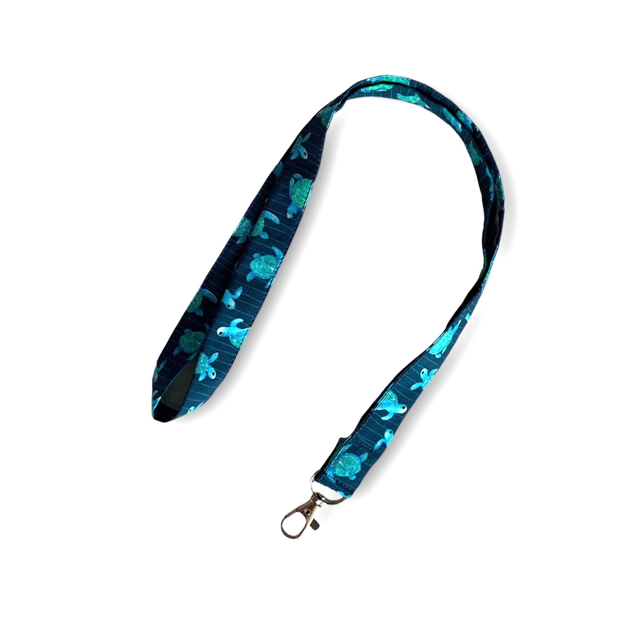 Laccetto portabadge con una combinazione di colori che esalta la bellezza di queste tartarughe disegnate ad effetto acquerello e ricorda le profondità del mare in cui vivono queste splendide creature