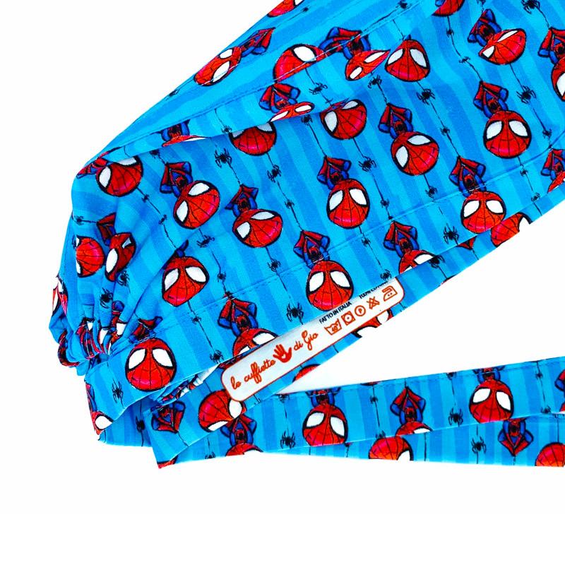 Cuffietta chirurgica con personaggio rosso appeso a testa in giù a ragnatele, con piccoli ragni neri, sfondo azzurro a righe chiare e scure
