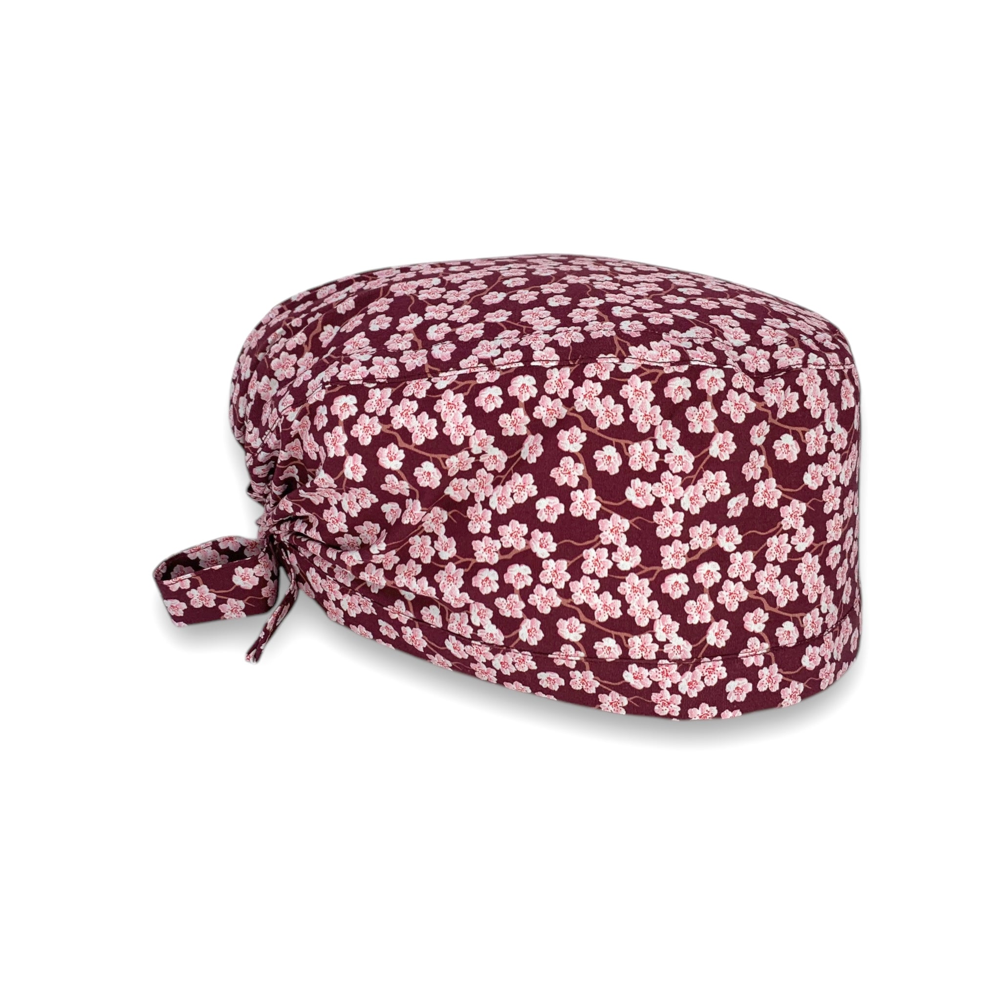 Cuffietta chirurgica con piccoli fiori di ciliegio rosa su base bordeaux