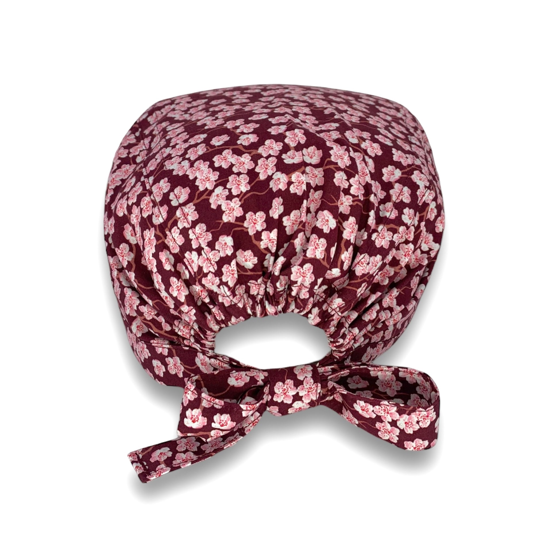Cuffietta chirurgica con piccoli fiori di ciliegio rosa su base bordeaux