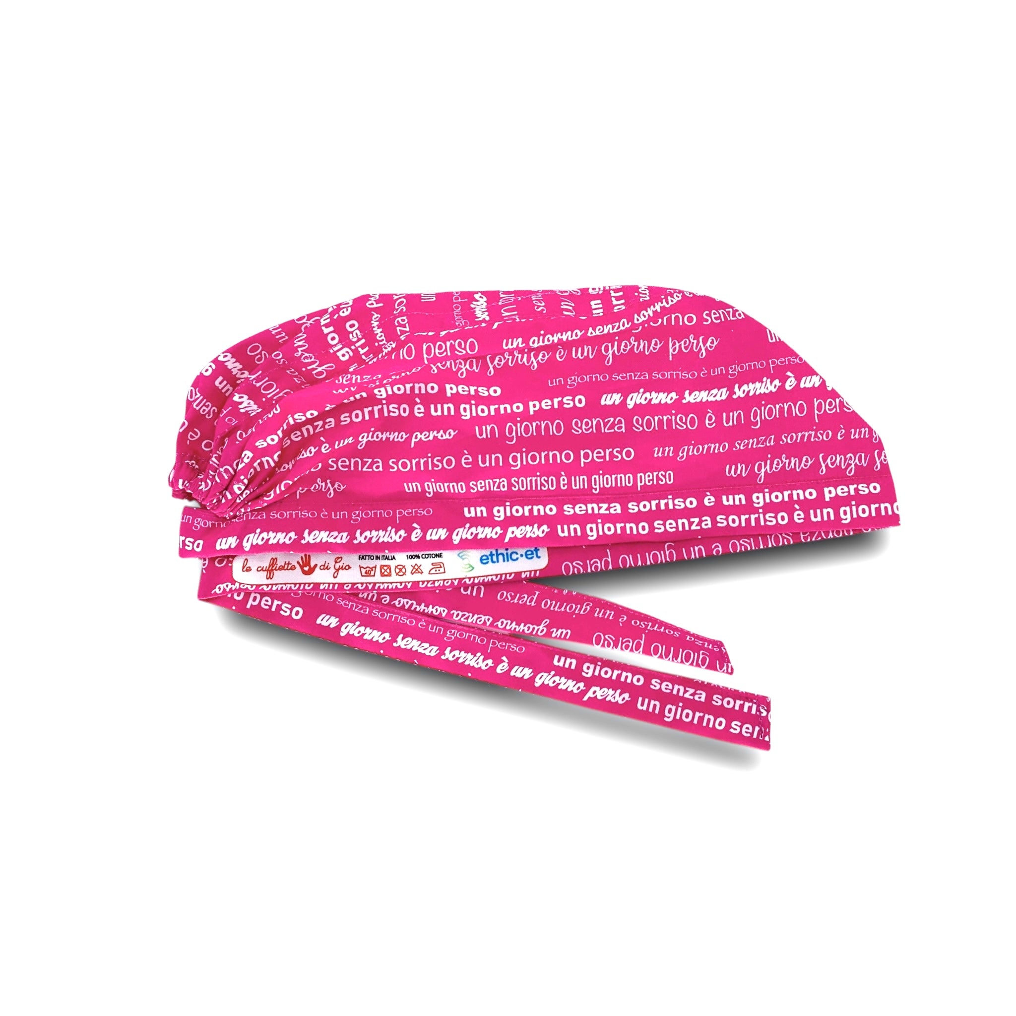 Una cuffietta con il design perfetto per chi si occupa del sorriso delle persone: la frase celebre di Charlie Chaplin "un giorno senza sorriso è un giorno perso" ripetuta con diversi font su tutta la superficie della cuffia, su fondo fucsia