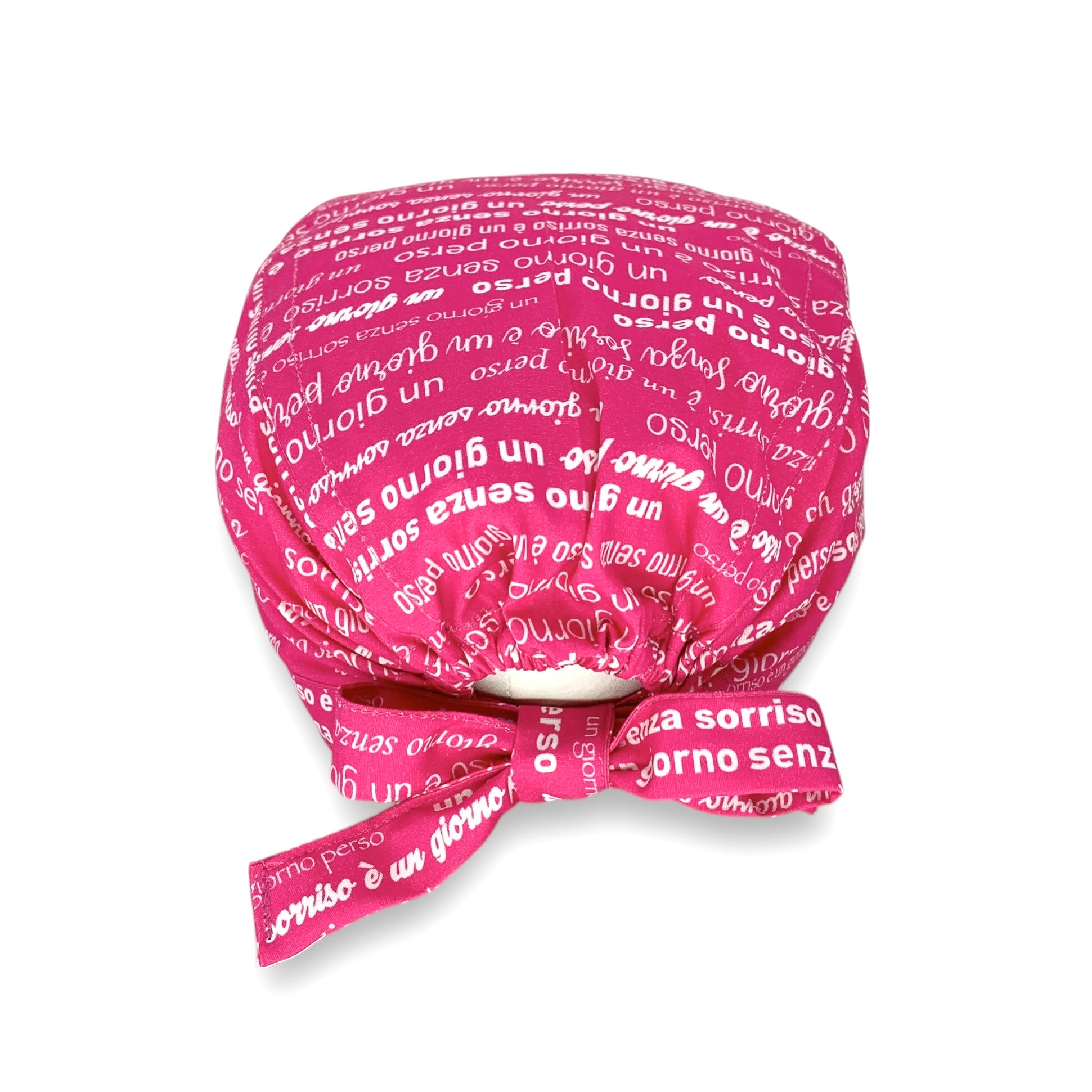 Una cuffietta con il design perfetto per chi si occupa del sorriso delle persone: la frase celebre di Charlie Chaplin "un giorno senza sorriso è un giorno perso" ripetuta con diversi font su tutta la superficie della cuffia, su fondo fucsia