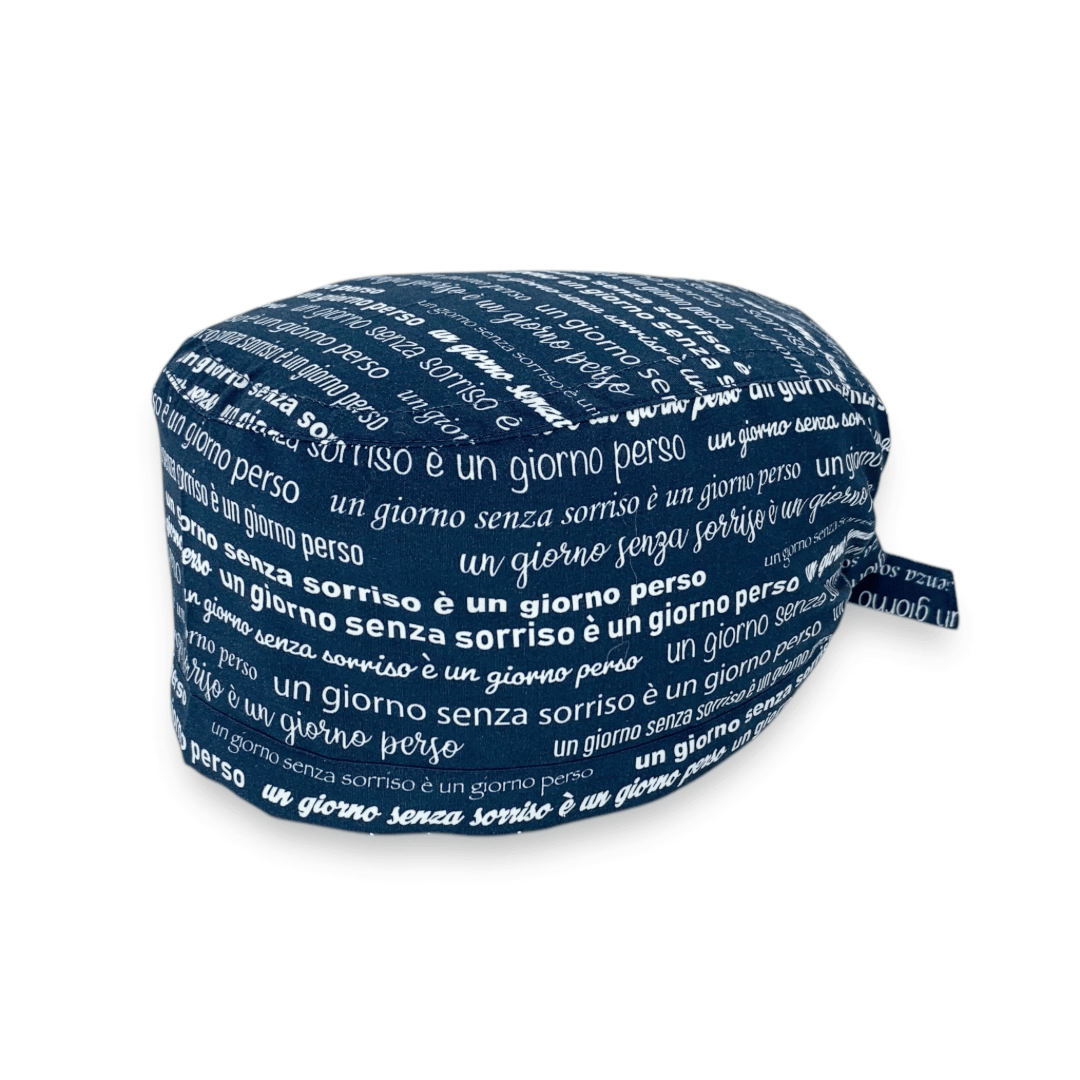 Una cuffietta con il design perfetto per chi si occupa del sorriso delle persone: la frase celebre di Charlie Chaplin "un giorno senza sorriso è un giorno perso" ripetuta con diversi font su tutta la superficie della cuffia, su fondo fucsia o blu