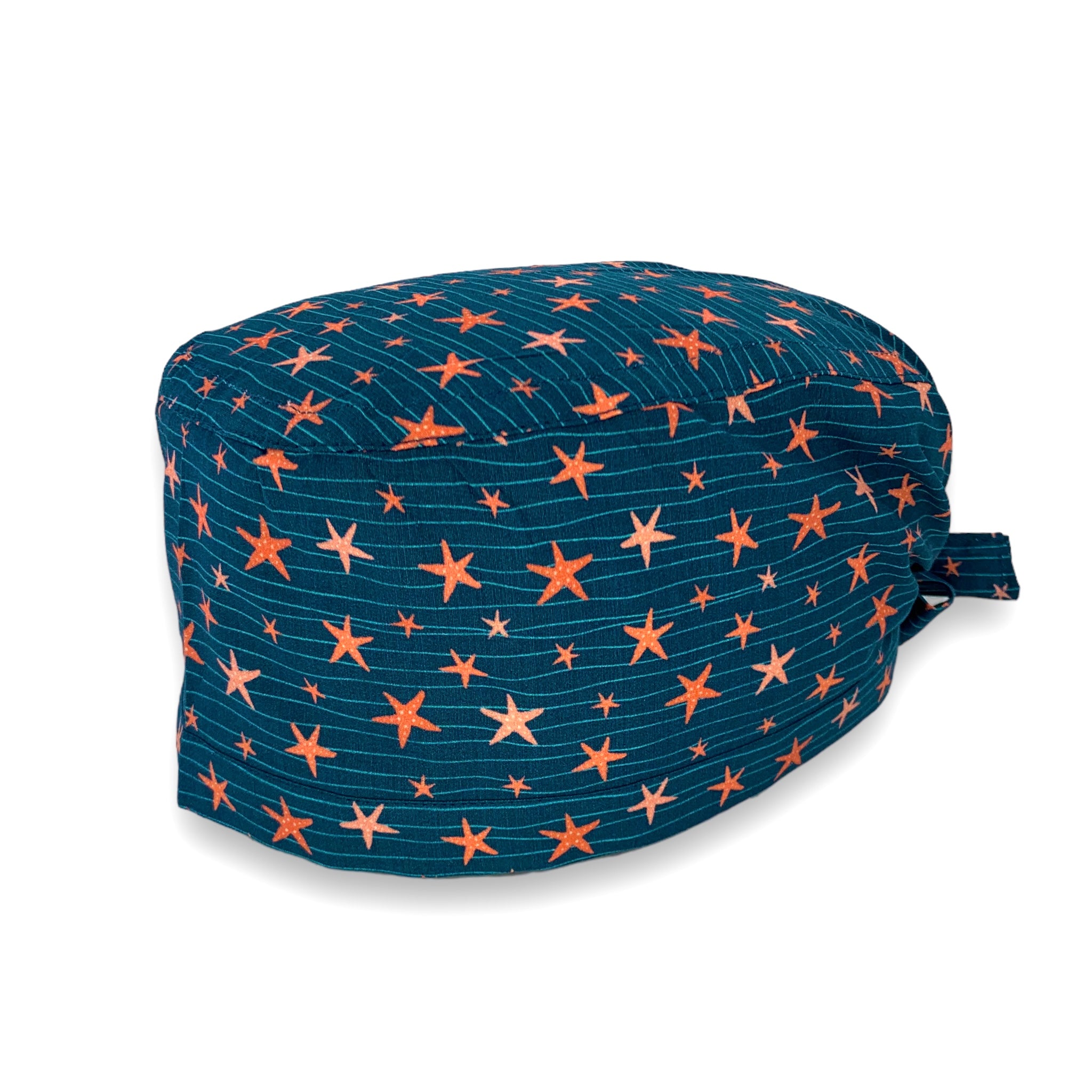 Cuffietta chirurgica con piccole stelle marine di diverse sfumature color corallo danzano su delicate onde verde acqua, sfondo blu avio