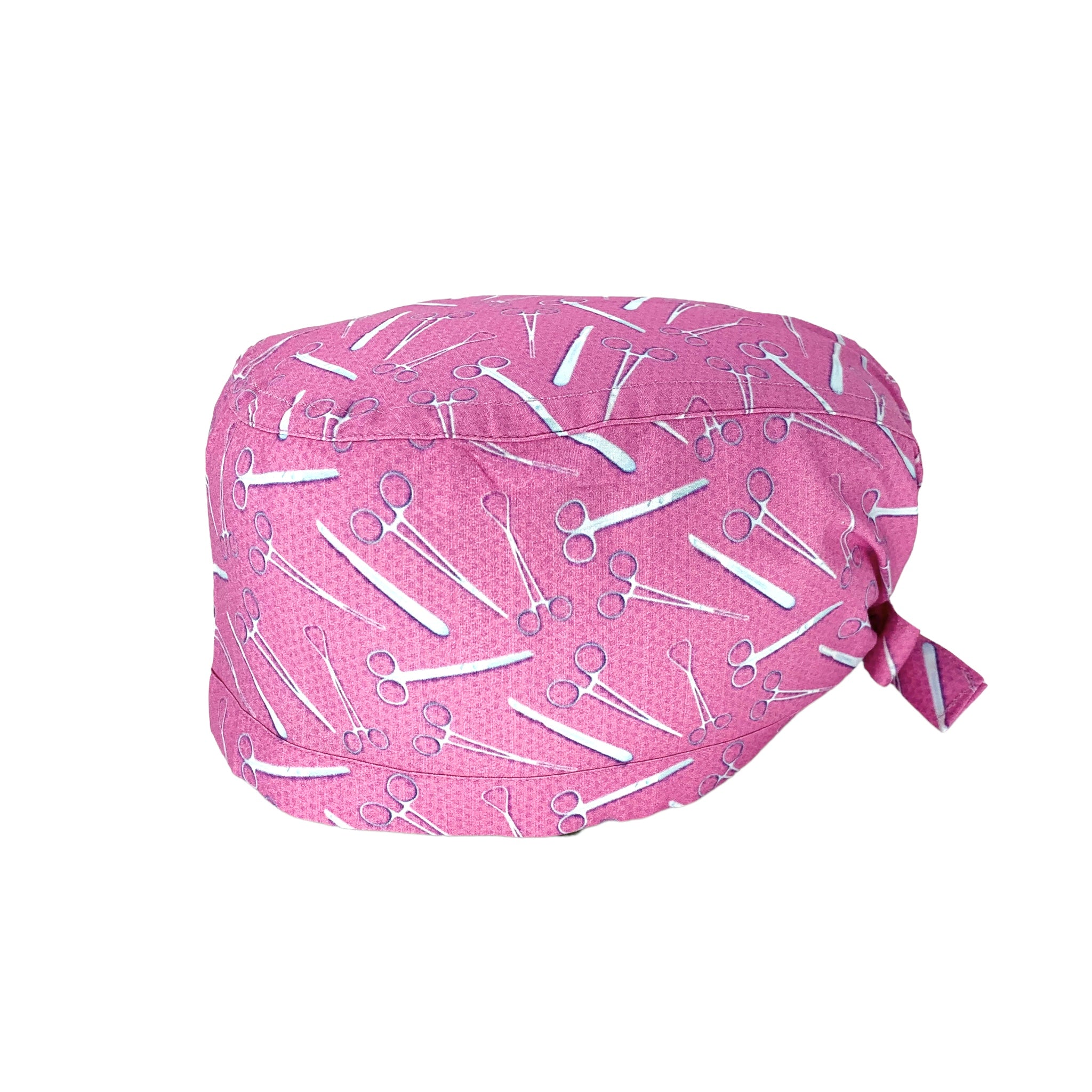 Cuffietta con strumenti chirurgici color metallo su sfondo rosa intenso