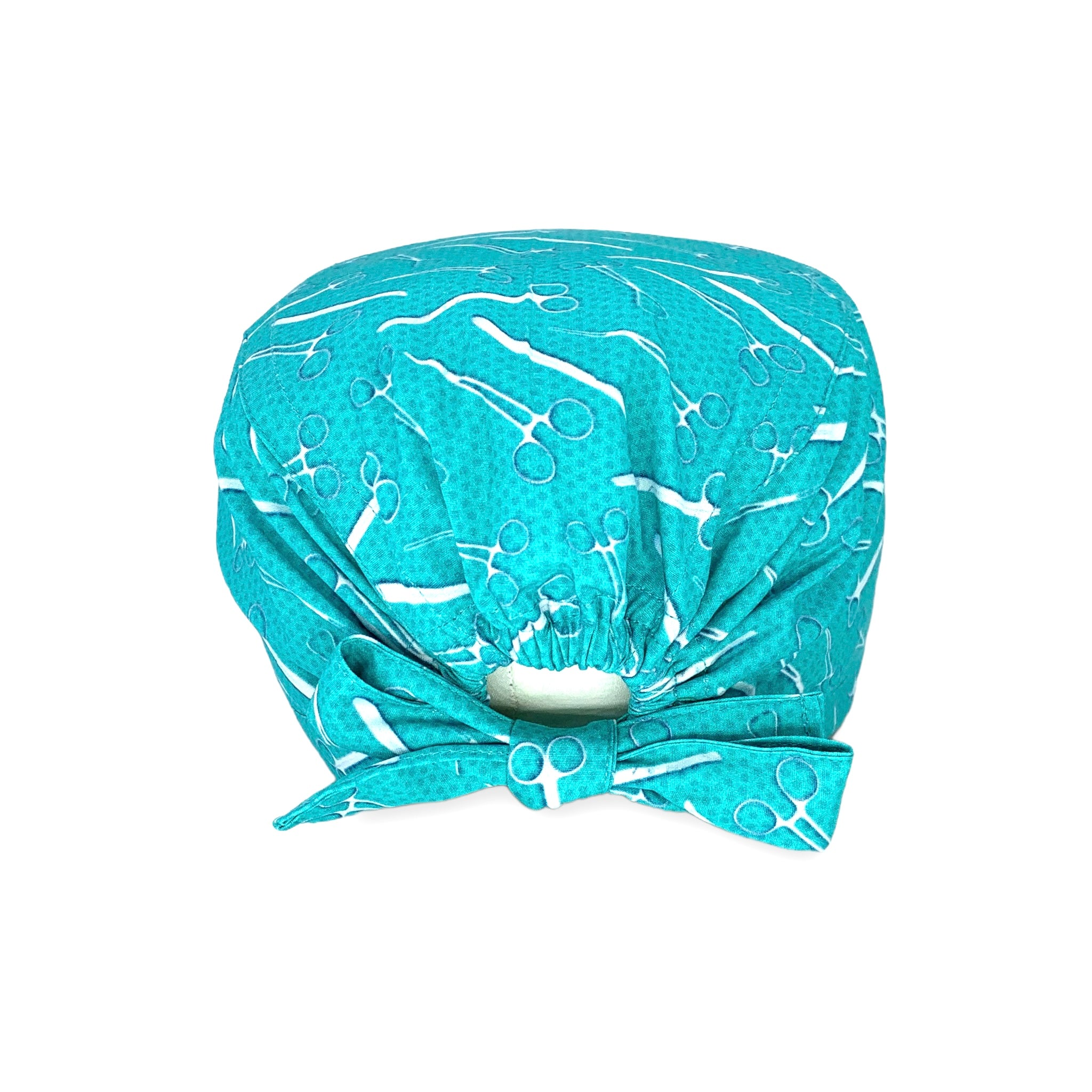 Cuffietta con strumenti chirurgici color metallo su sfondo verde acqua