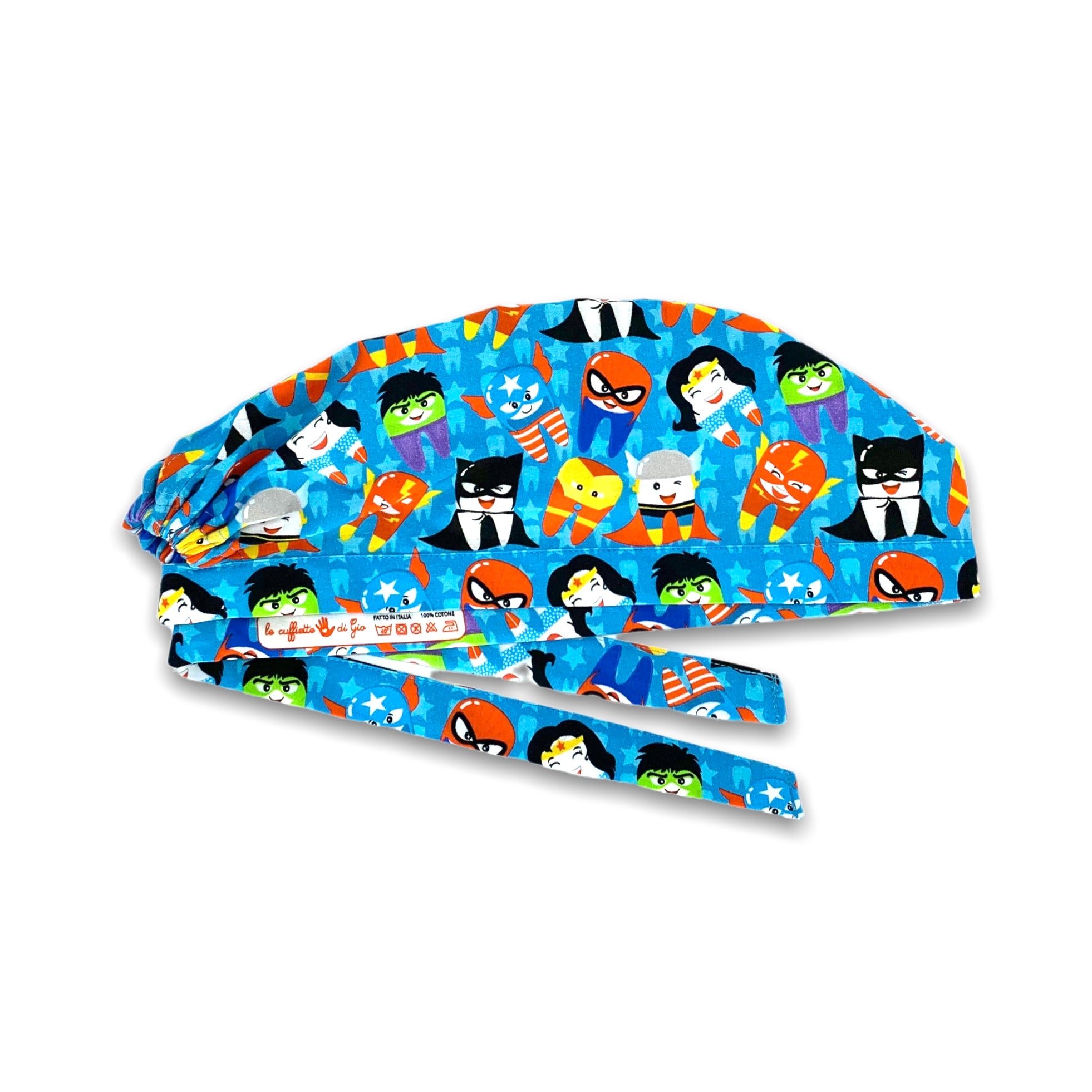 Cuffietta chirurgica con denti travestiti da super eroi; sullo sfondo azzurro intenso e un pattern di stelline e dentini tono su tono