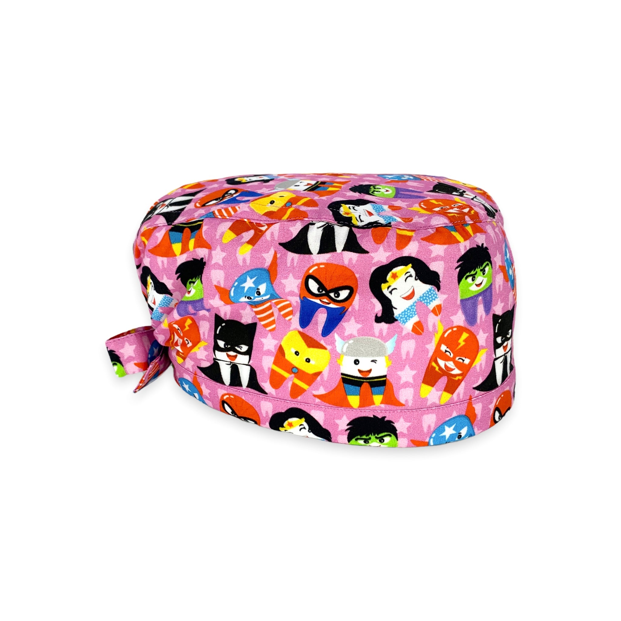 Cuffietta chirurgica con denti travestiti da super eroi; sullo sfondo rosa e un pattern di stelline e dentini tono su tono