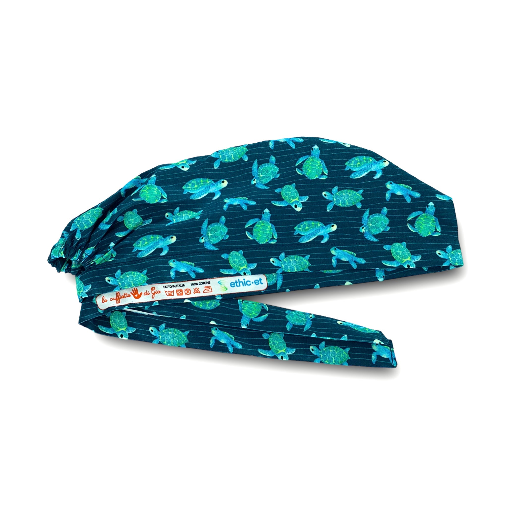 Cuffietta chirurgica blu avio con tartarughe disegnate ad effetto acquerello nei toni del turchese, sullo sfondo piccole righe ondulate che ricordano la profondità del mare
