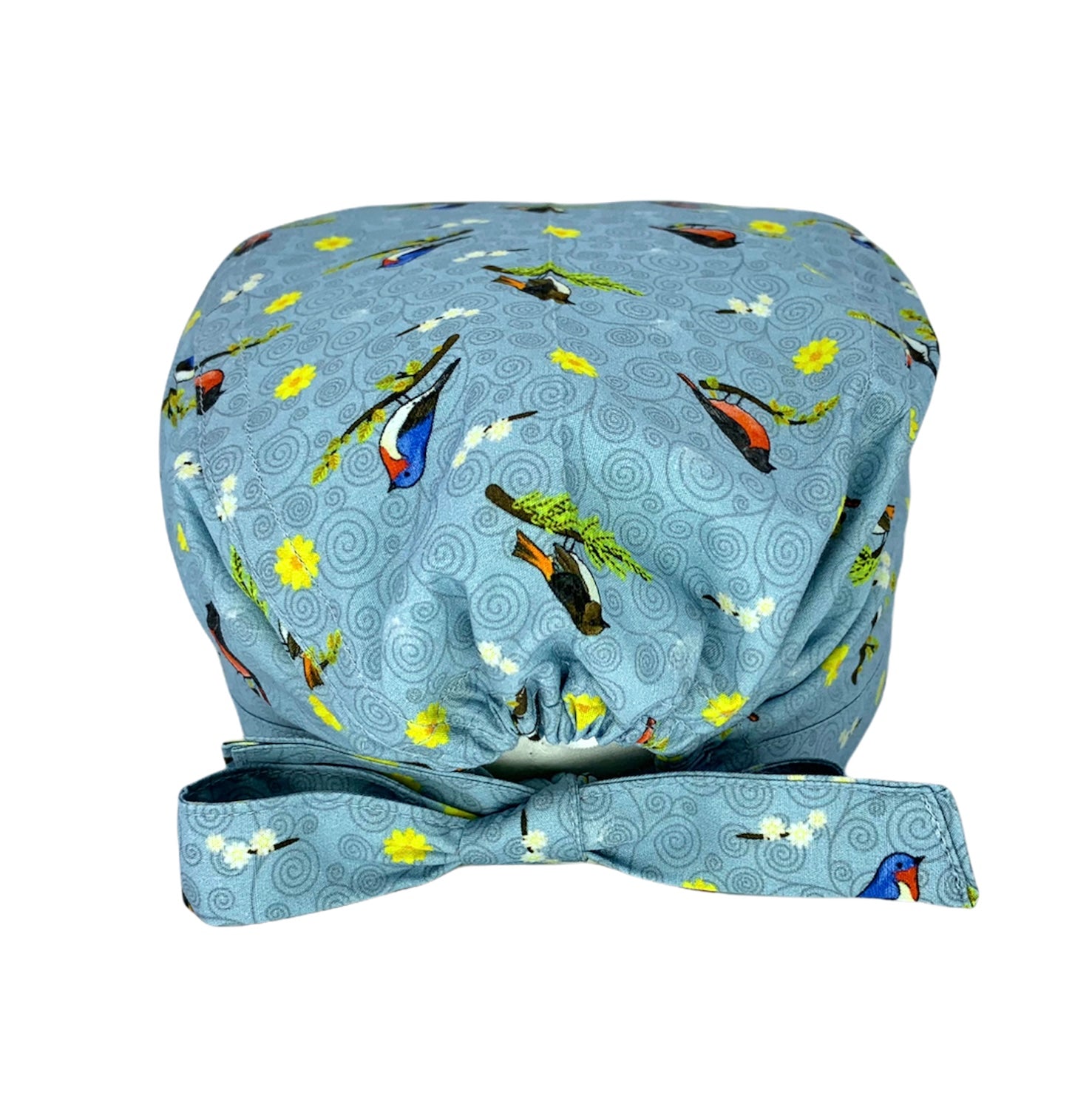 Cuffietta chirurgica grigio ceruleo con piccoli uccellini su rami, fiorellini gialli e bianchi e sullo sfondo piccoli vortici tono su tono. La cuffietta indossata dalla Dott.ssa Teddy Altman in Grey's Anatomy.