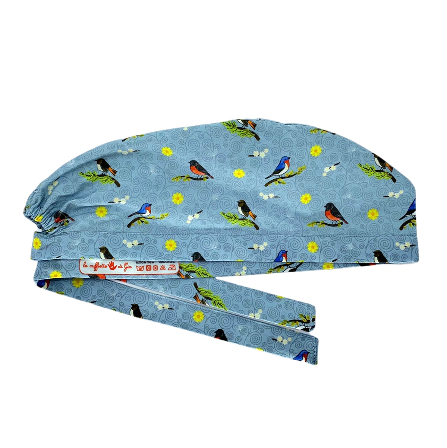 Cuffietta chirurgica grigio ceruleo con piccoli uccellini su rami, fiorellini gialli e bianchi e sullo sfondo piccoli vortici tono su tono. La cuffietta indossata dalla Dott.ssa Teddy Altman in Grey's Anatomy.