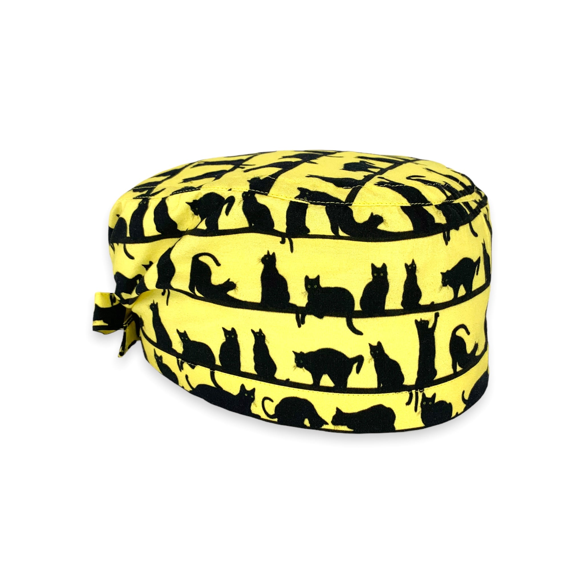 Cuffietta chirurgica con file di piccoli gatti neri realistici in pose tipicamente feline, sfondo giallo