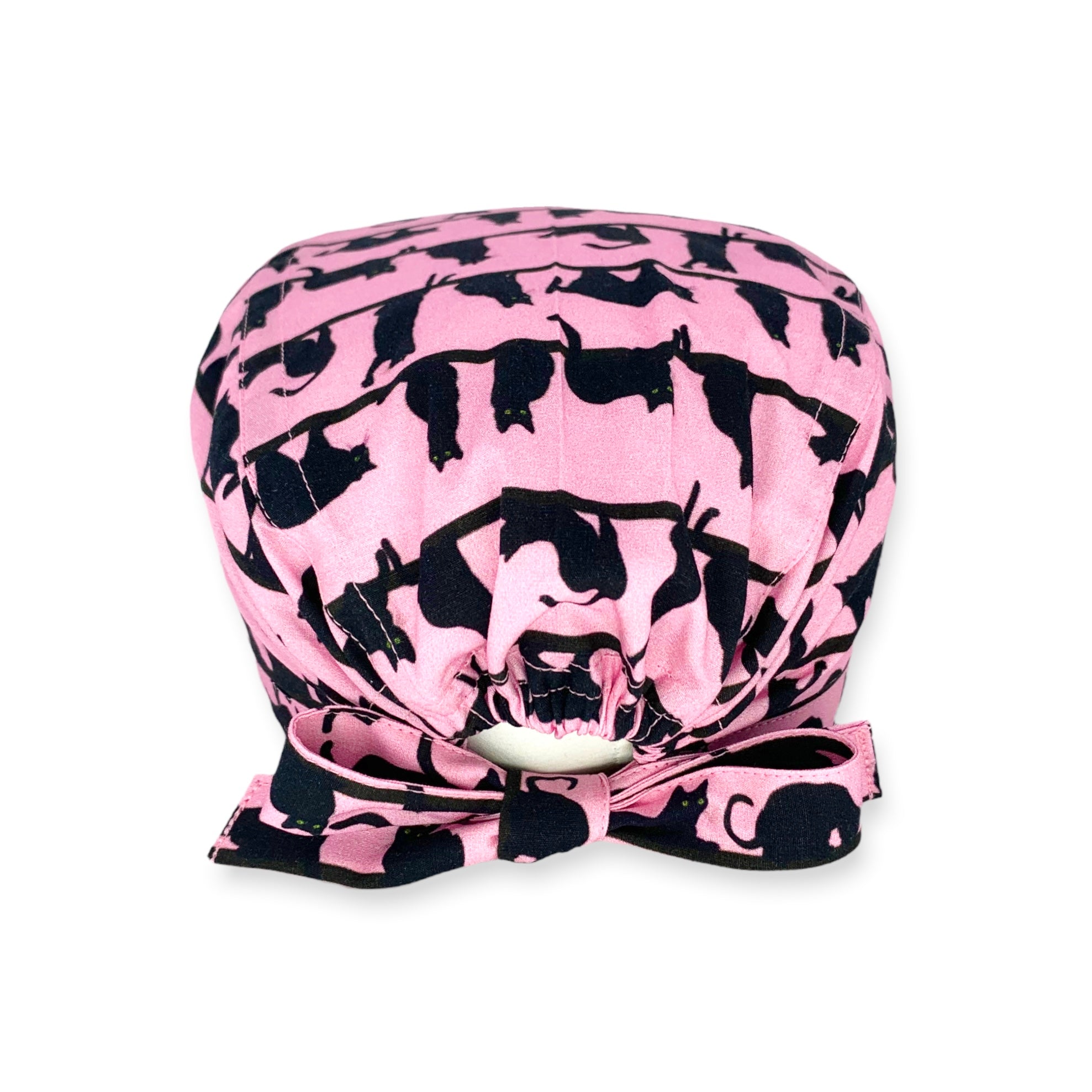 Cuffietta chirurgica con file di piccoli gatti neri realistici in pose tipicamente feline, sfondo rosa