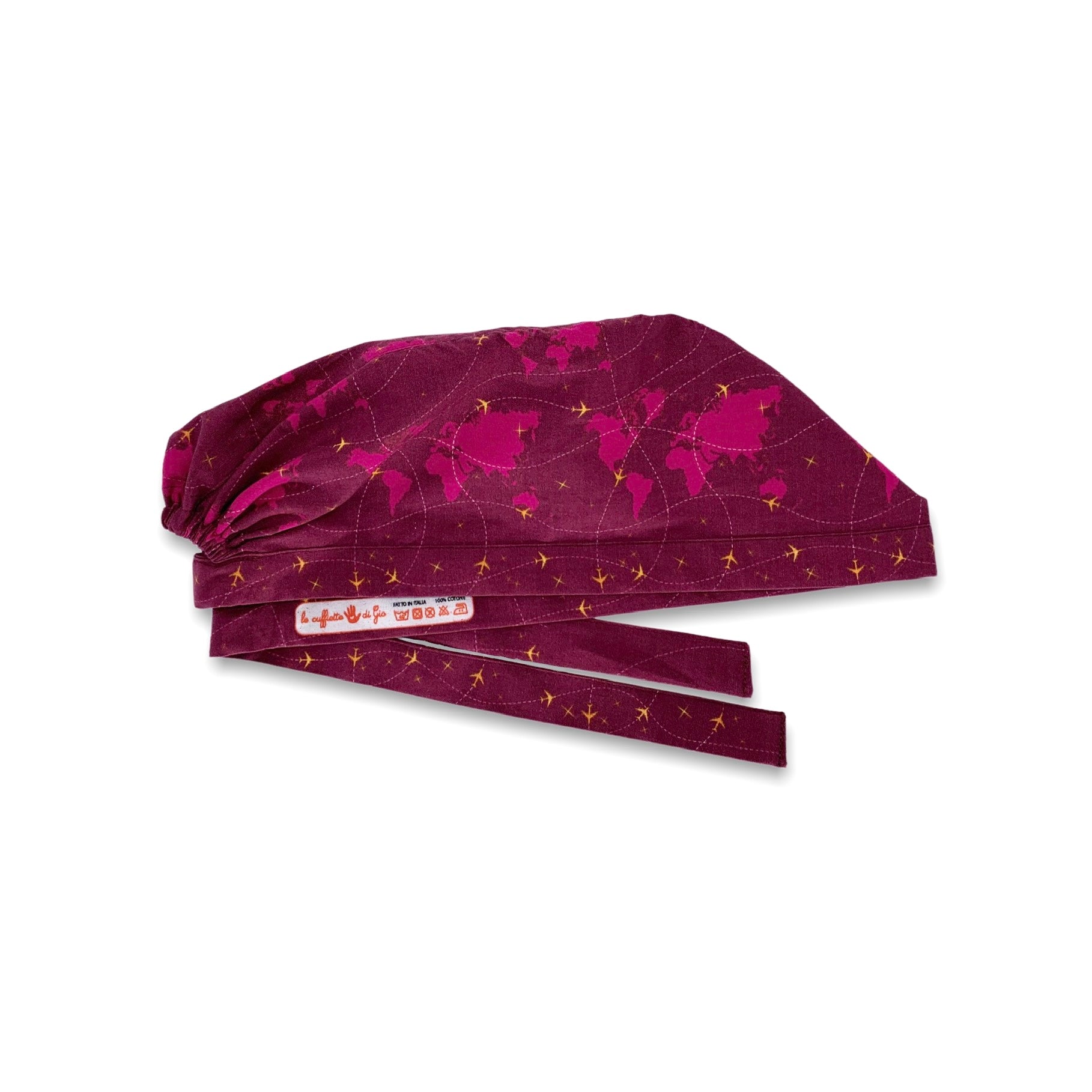 Cuffietta chirurgica con mappamondo e piccoli aerei gialli che tracciano delle linee tratteggiate, sfondo bordeaux