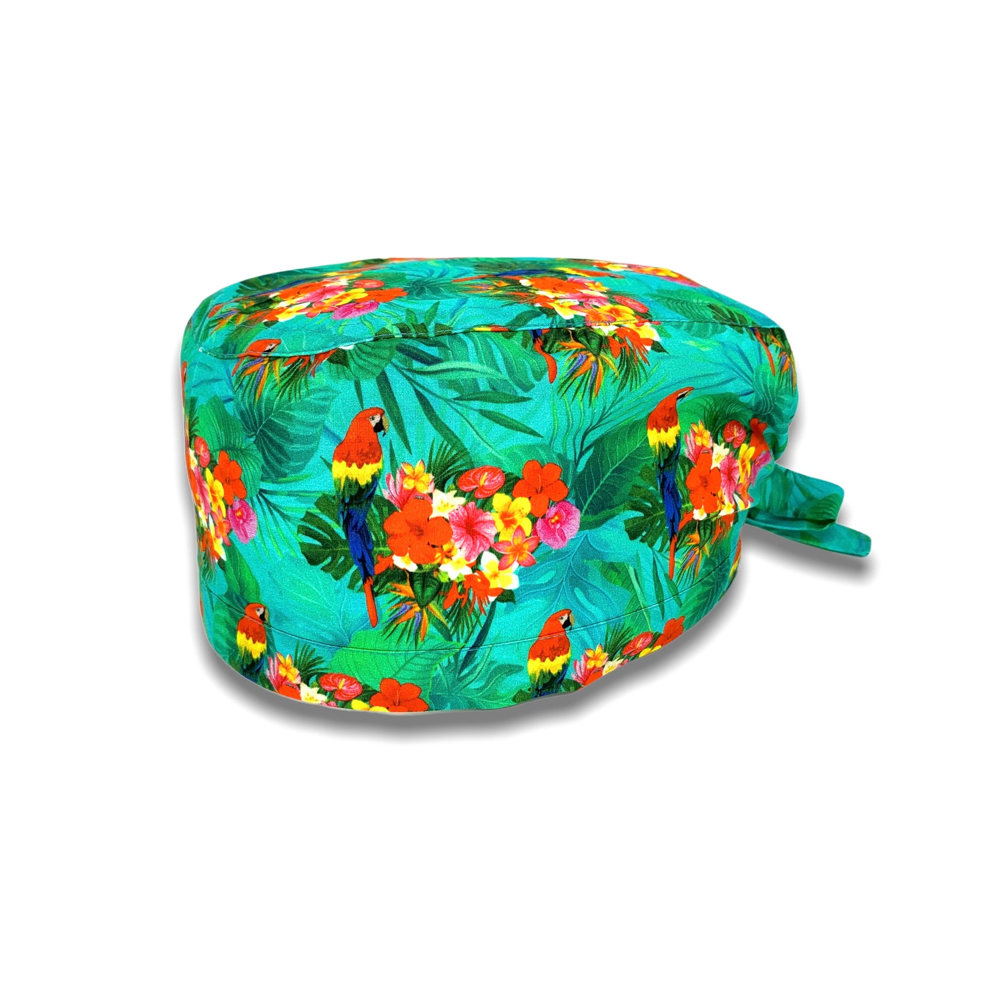 Cuffietta chirurgica verde con foglie tropicali, cacatua con lunga coda colorata in mezzo a un boquet di fiori tropicali