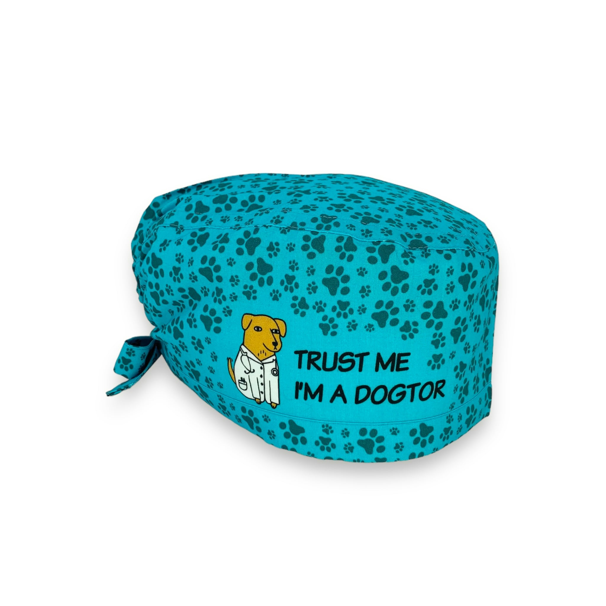 Una cuffietta simpaticissima! Mille impronte di cane tono su tono su UNA BASE AZZURRO INTENSOcui si apre uno spazio con disegnato un cane con un camice medico e uno stetoscopio al collo e la frase "TRUST ME I'M A DOGTOR"