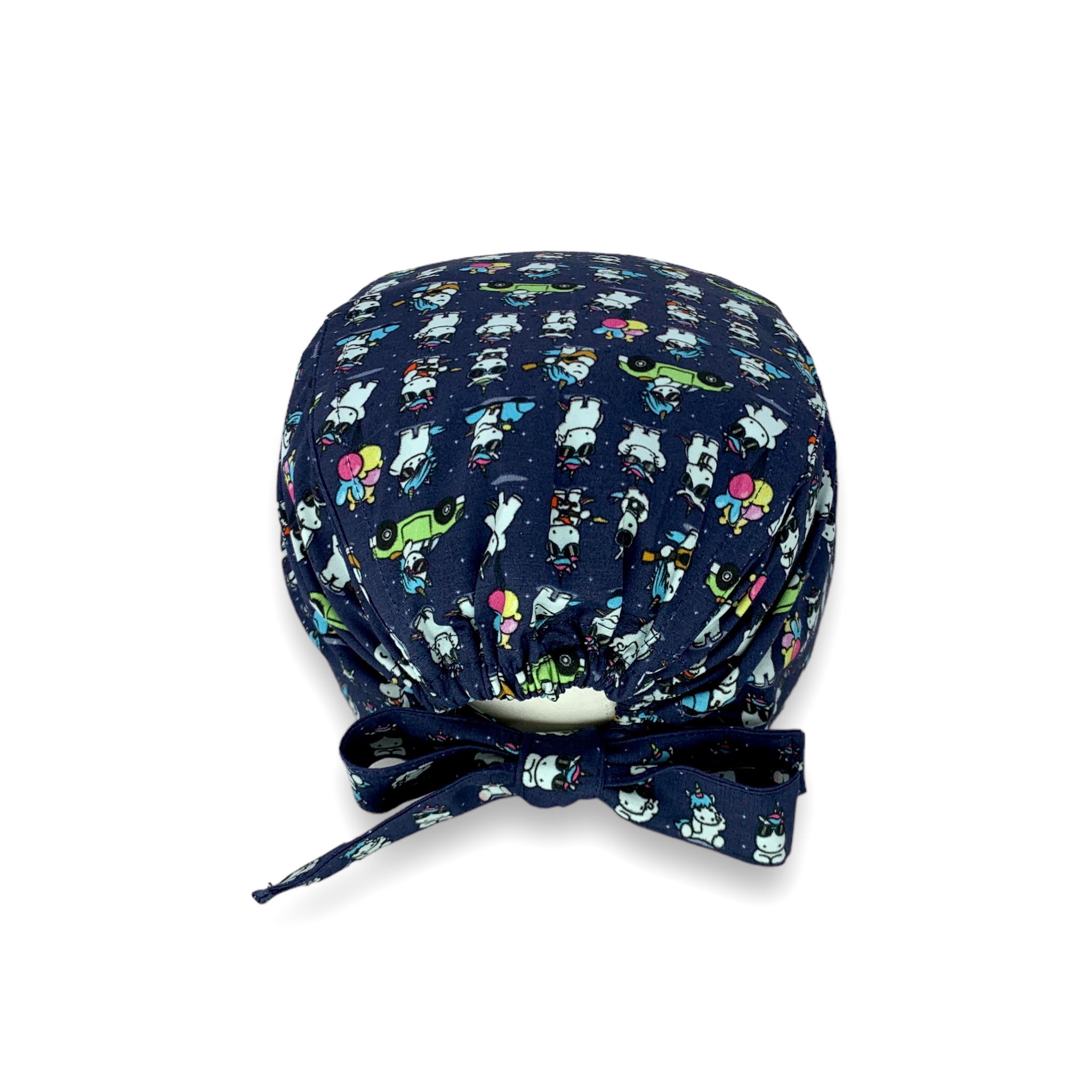 Cuffietta chirurgica con piccoli unicorni bianchi disegnati in stile kawaii, in varie posizioni mollto buffe: in macchina, in scooter, mentre suona la chitarra. Sfondo blu