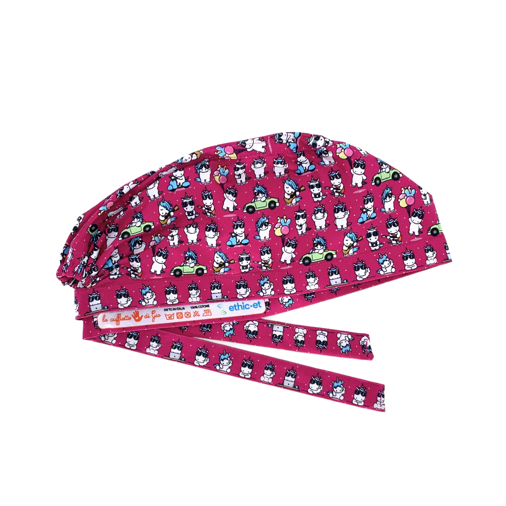 Cuffietta chirurgica con piccoli unicorni bianchi disegnati in stile kawaii, in varie posizioni mollto buffe: in macchina, in scooter, mentre suona la chitarra. Sfondo magenta