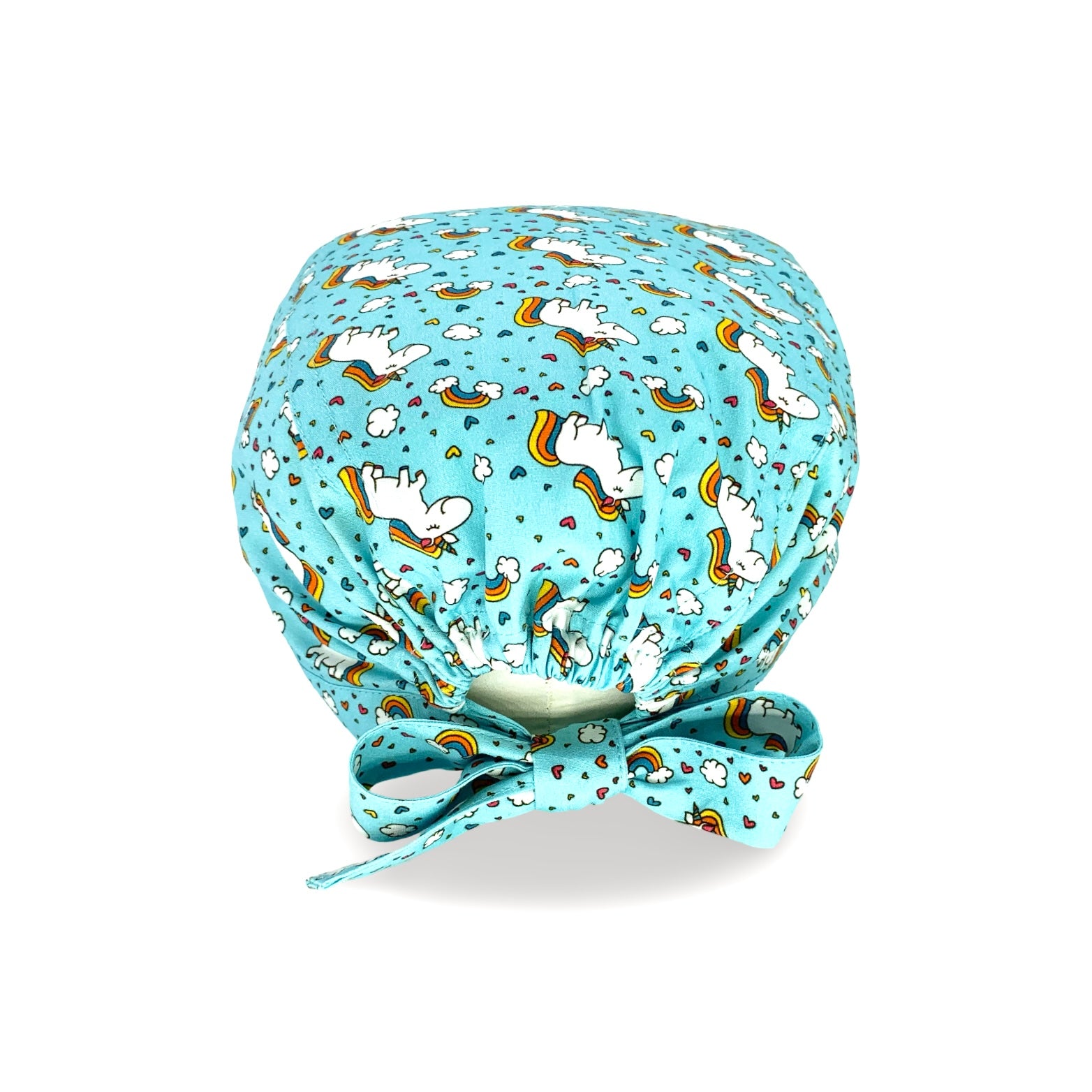Cuffietta chirurgica con unicorni bianchi tra nuvolette e arcobaleni. Su fondo azzurro.