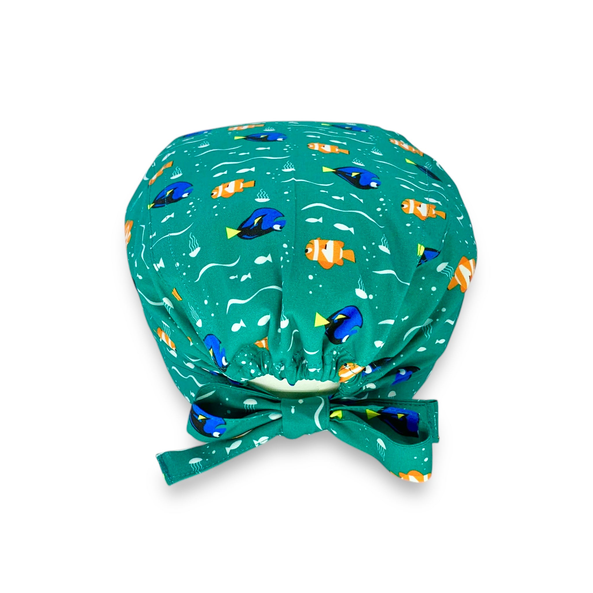 Una cuffietta con sfordo verde intenso e un semplice pattern con un pesce arancione e un pesce blu, entrambi sorridenti. Il mare e i pesci, un binomio infallibile per mettere a proprio agio anche il più ansioso dei pazienti!