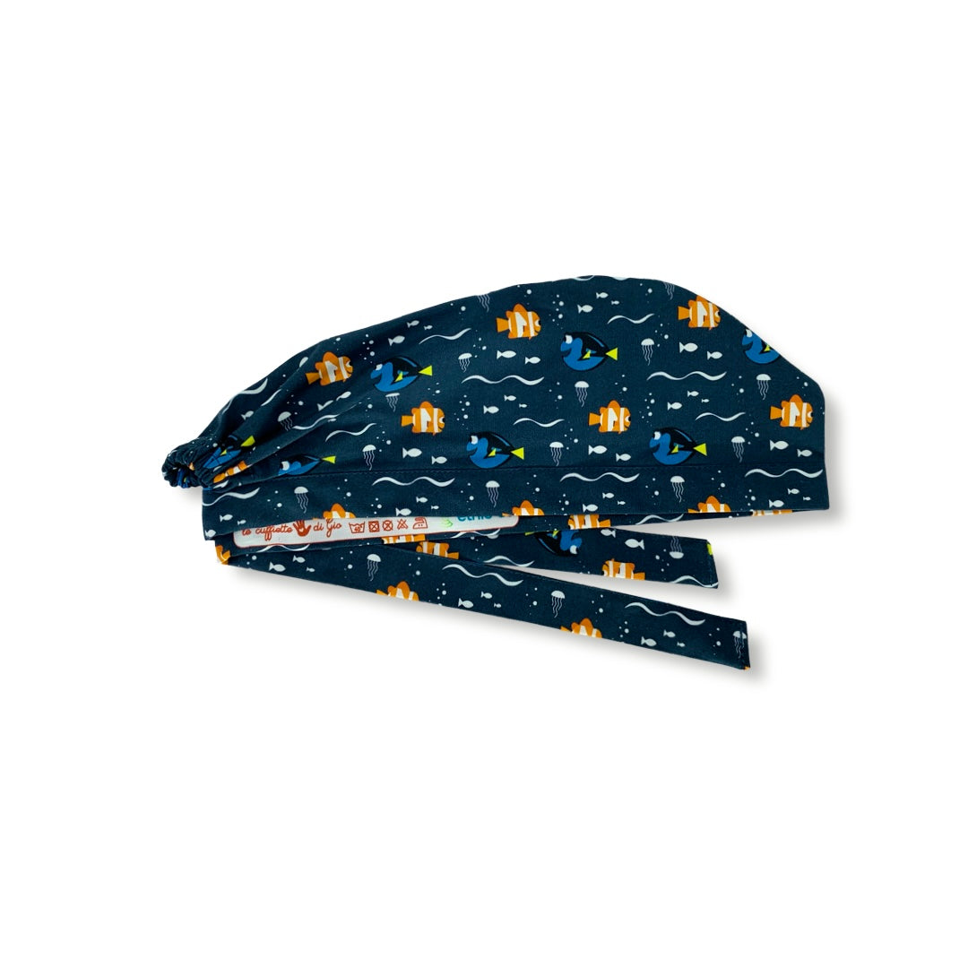 Una cuffietta con sfondo blu scuro e un semplice pattern con un pesce arancione e un pesce blu, entrambi sorridenti. Il mare e i pesci, un binomio infallibile per mettere a proprio agio anche il più ansioso dei pazienti!