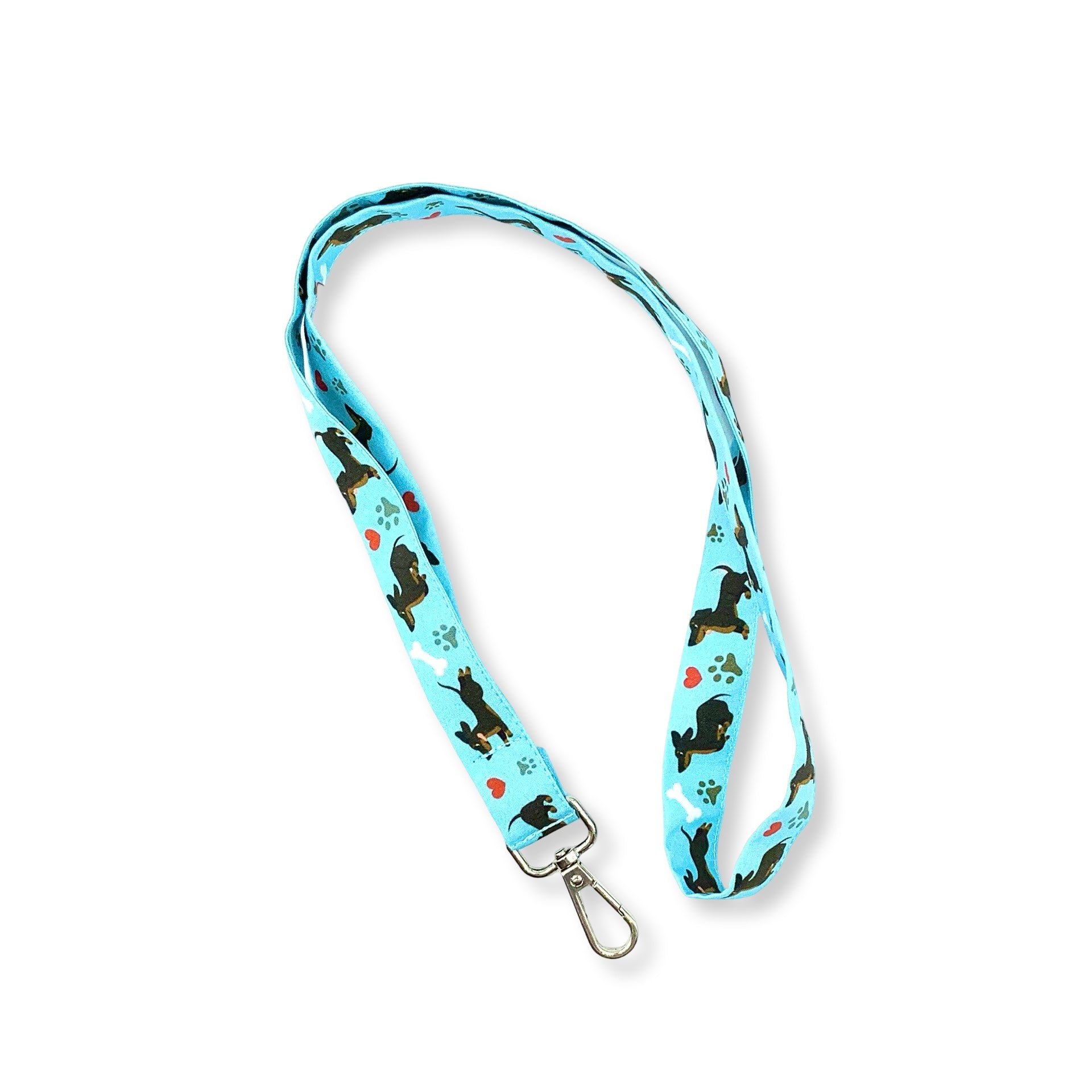 Un simpatico bassotto corre felice fra impronte di zampette, ossi da sgranocchiare e cuoricini in una combinazione di colori vincente per questa laccetto portabadge!. È lungo 45 cm e corredato di moschettone in metallo separabile per il lavaggio grazie al bottone automatico