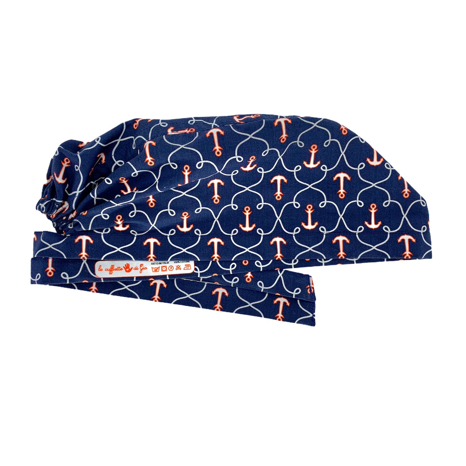 Foto laterale cuffietta appiattita stirata. Con logo le cuffiette di gio stampato su laccio interno. Una fantasia marinara per una cuffietta chirurgica classica ed elegante anche in sala operatoria. Cuffia a fondo blue con ancore e cime bianche e rosse.