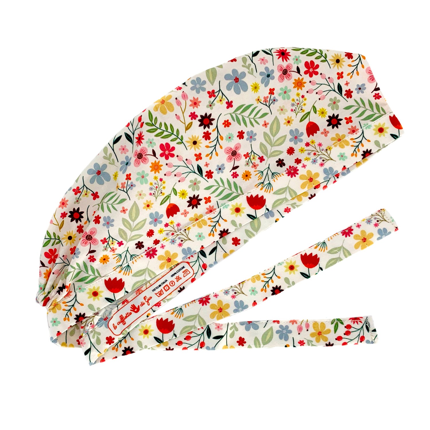 Cuffietta chirurgica con fiori nelle calde tonalità di rossi e gialli che si mescolano a foglie delicate, fiorellini rosa e azzurri per ricordare colori e profumi delle campagne. Sfondo panna