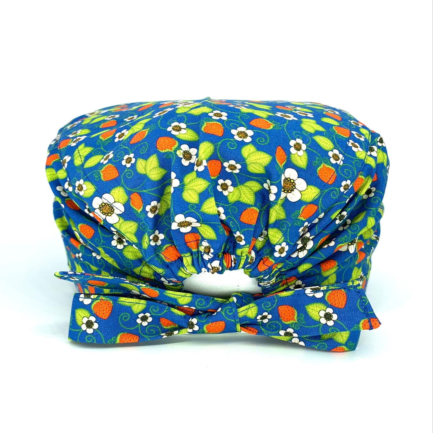 Cuffietta chirurgica con piccole piante di fragoline di bosco con i loro fiori bianchi che si intrecciano su una base blu medio, in perfetto stile Liberty of London.