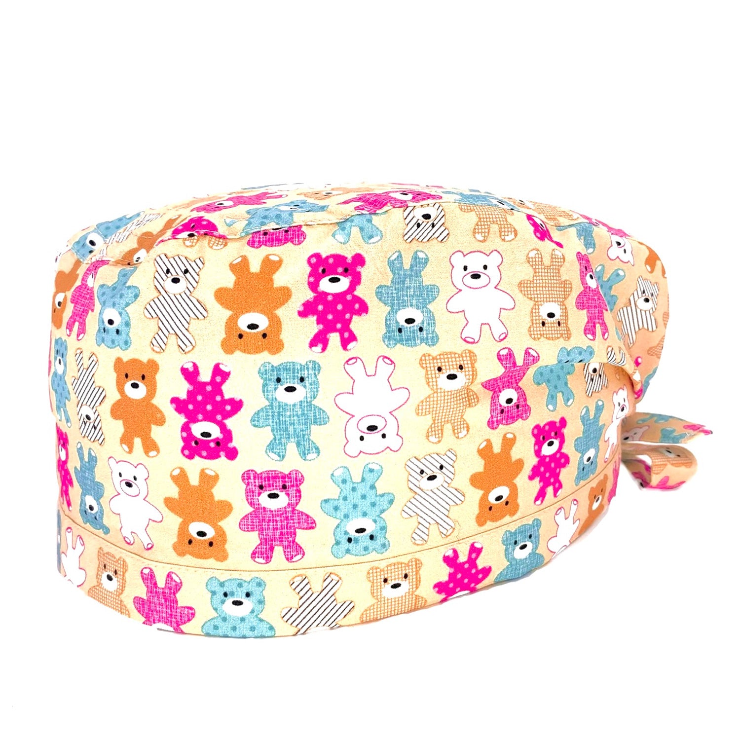 Foto frontale cuffietta chirurgica con disegnati orsetti di peluche di vari colori su sfondo beige