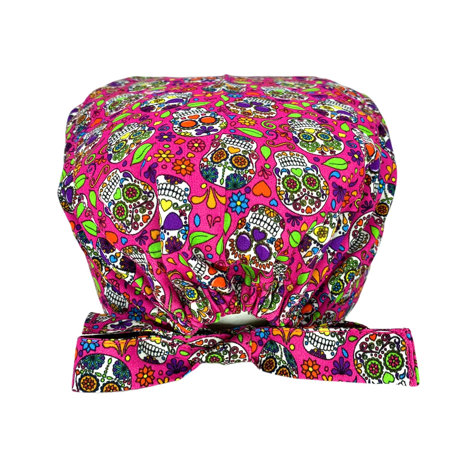 Cuffietta chirurgica con un disegno che oramai è diventato un classico: i coloratissimi teschi messicani. La cultura messicana immagina il regno dei morti come un mondo allegro e colorato, pieno di vitalità e di gioia. Trasformare la morte in un momento felice è un’idea geniale e profonda. Sfondo fucsia