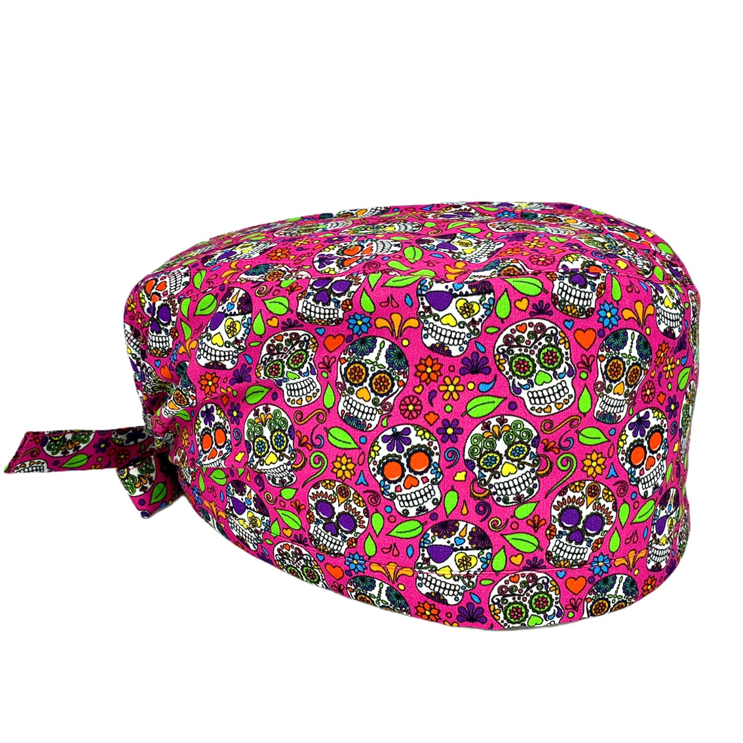 Cuffietta chirurgica con un disegno che oramai è diventato un classico: i coloratissimi teschi messicani. La cultura messicana immagina il regno dei morti come un mondo allegro e colorato, pieno di vitalità e di gioia. Trasformare la morte in un momento felice è un’idea geniale e profonda. Sfondo fucsia